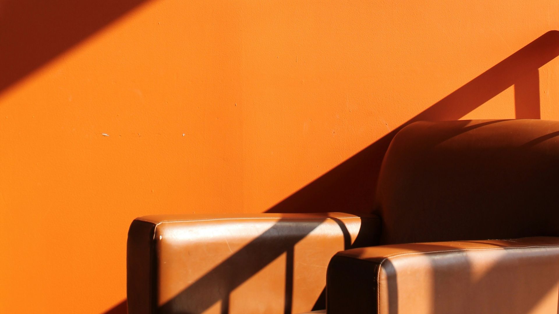 a chair sitting in front of an orange wall