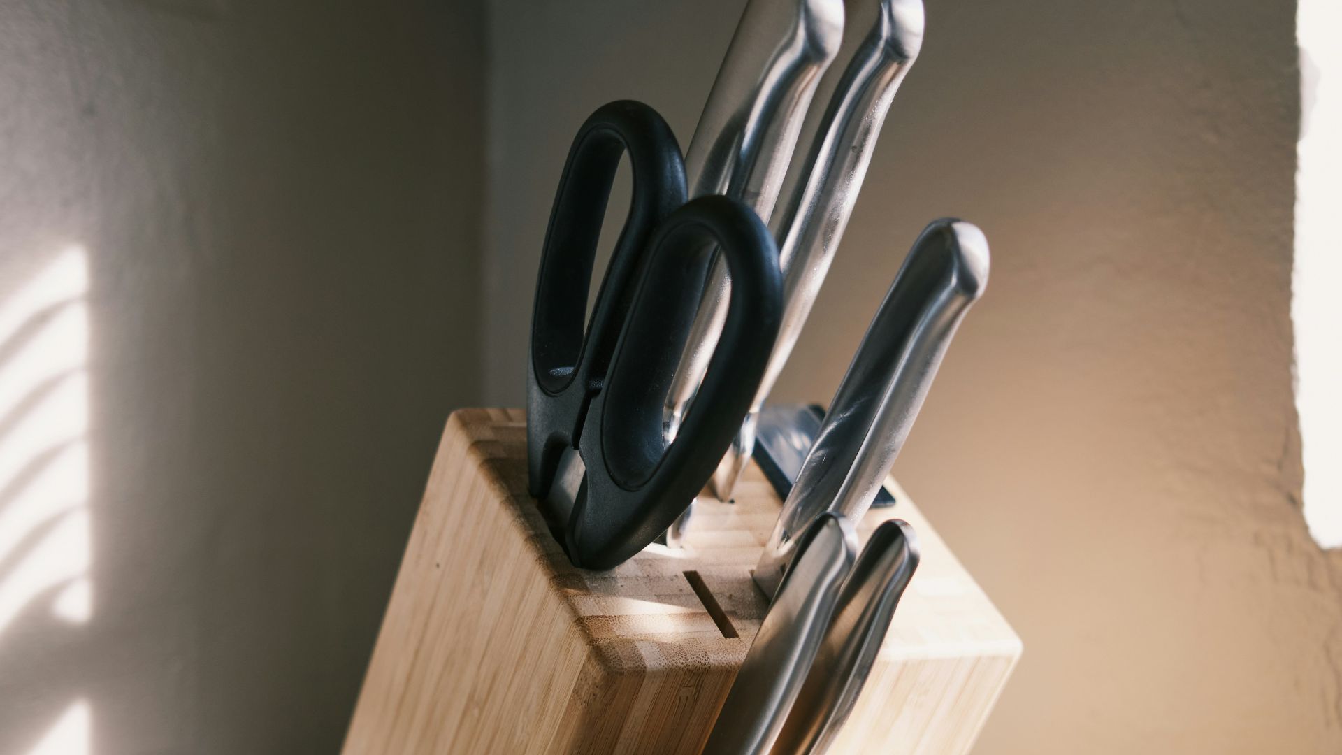 a wooden block with a knife holder holding knives