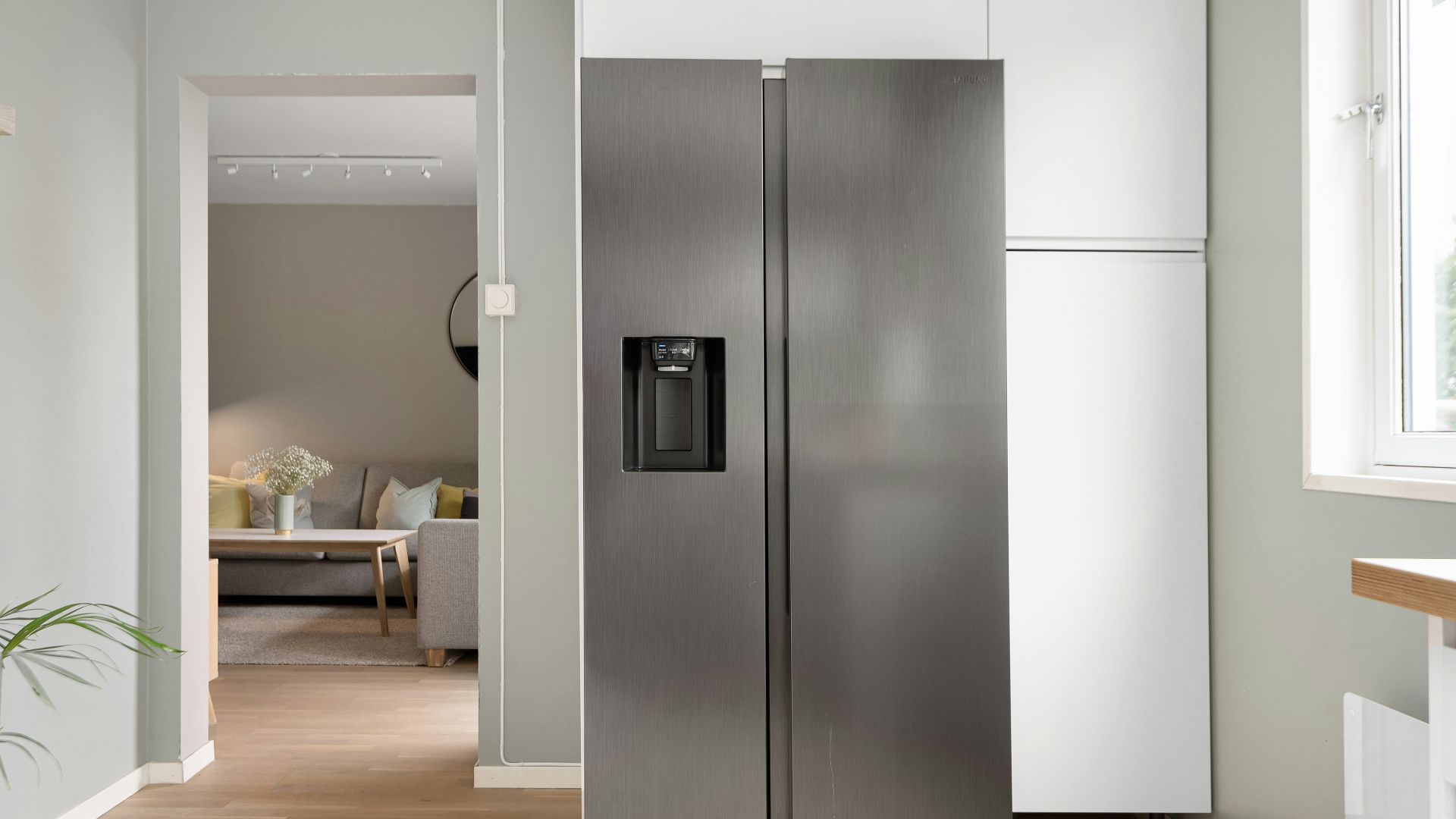 A refrigerator in a kitchen next to a window