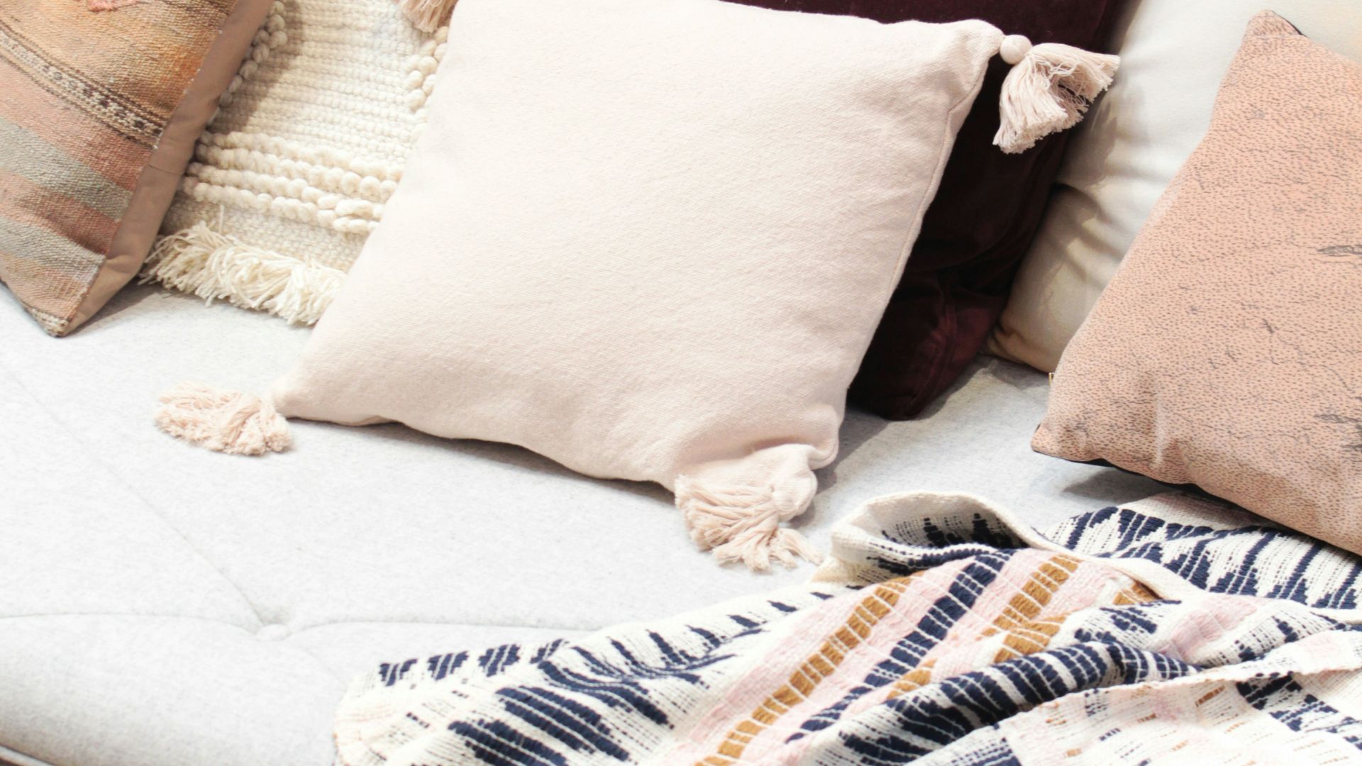 assorted throw pillows on gray couch