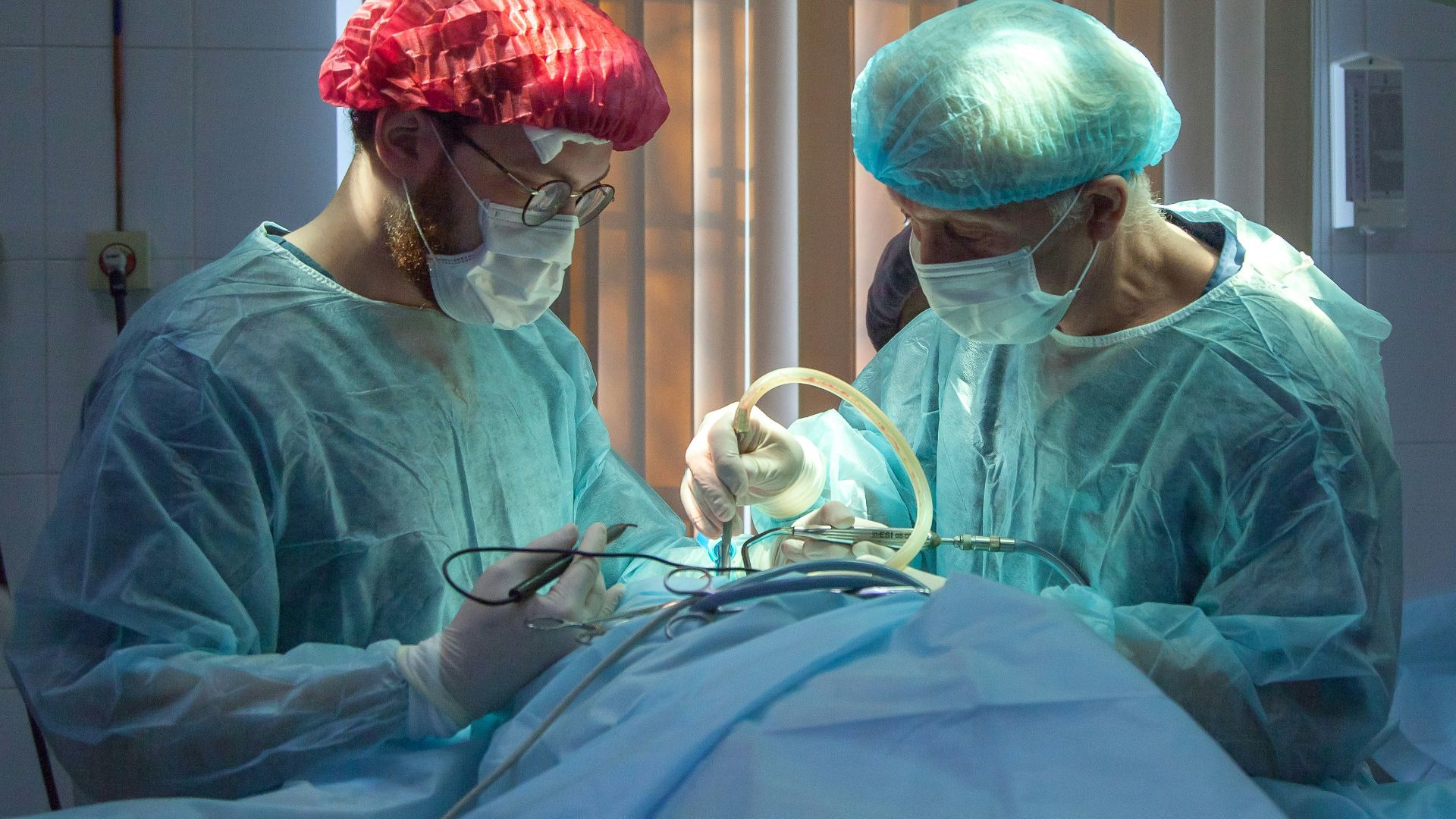 two men wearing blue lab coats