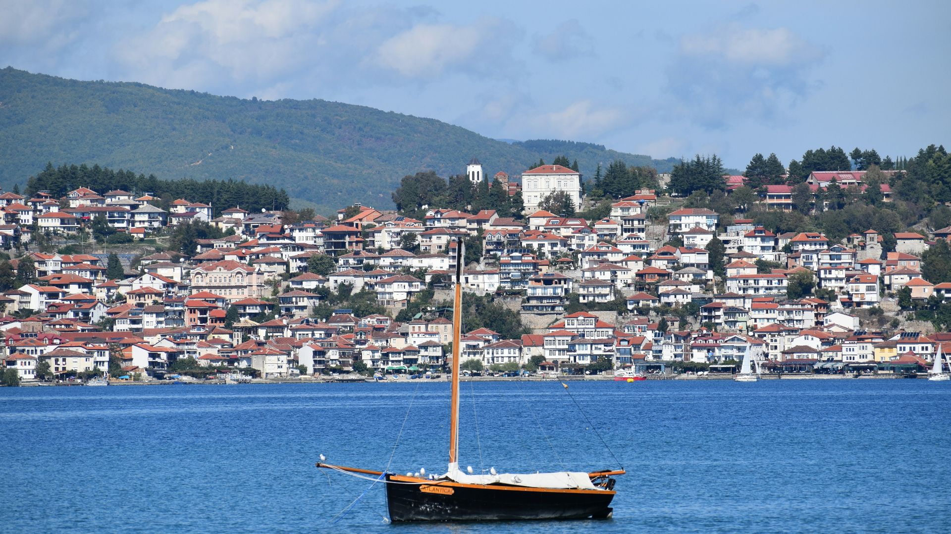 brown boat on body of water near city buildings during daytime