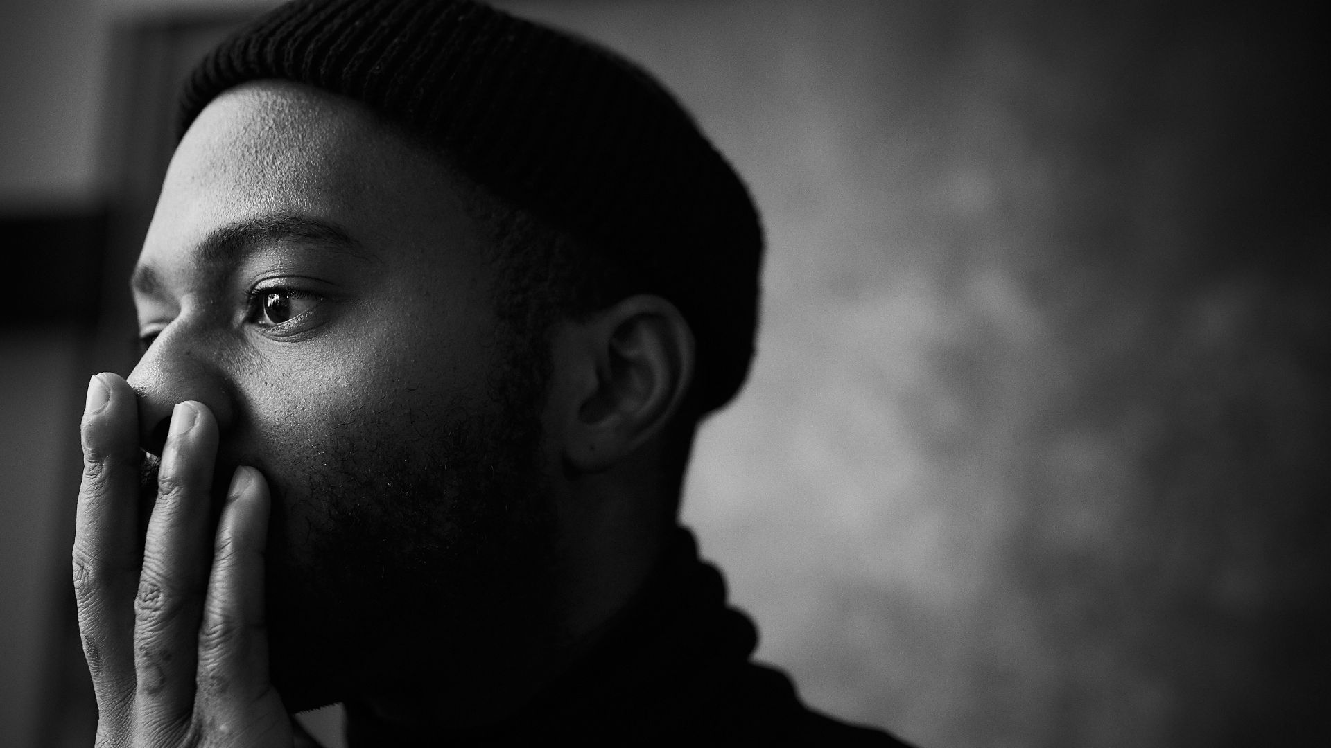 man in knit cap grayscale photo