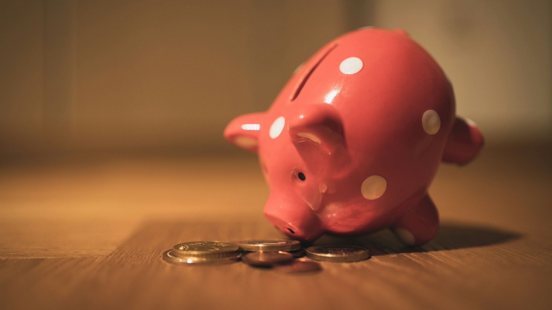 pink pig coin bank on brown wooden table