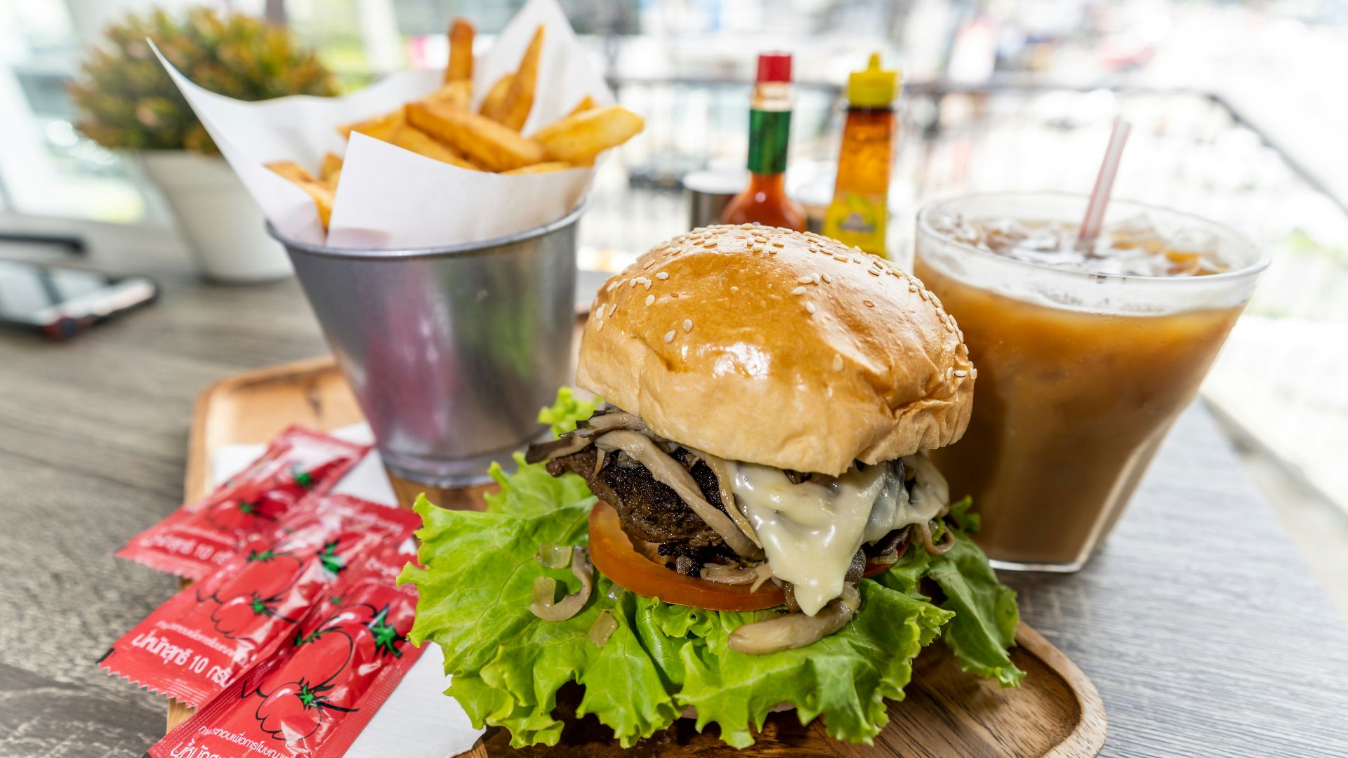 burger with lettuce and fries on brown wooden table