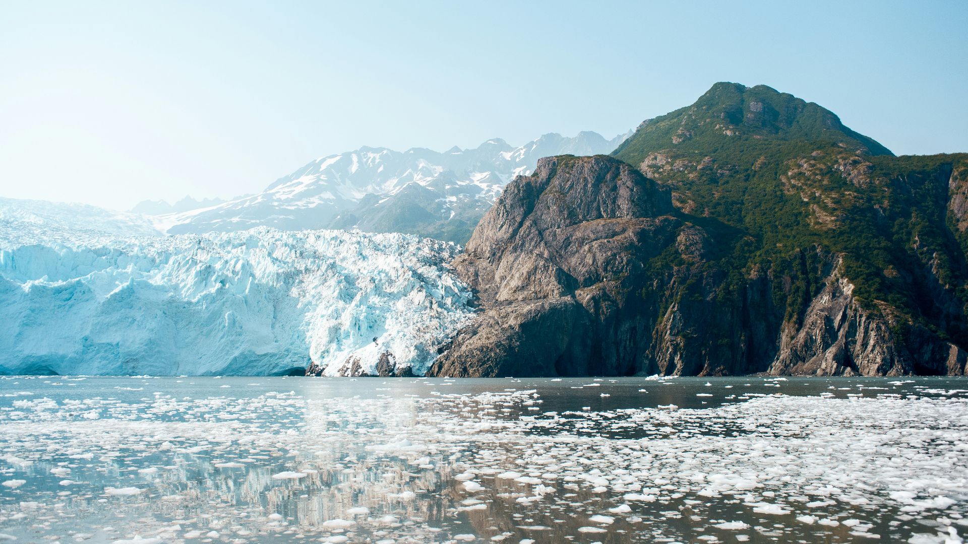 body of water near brown and green mountain
