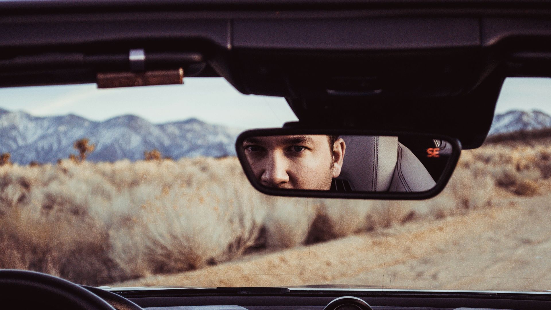person staring at rear view mirror