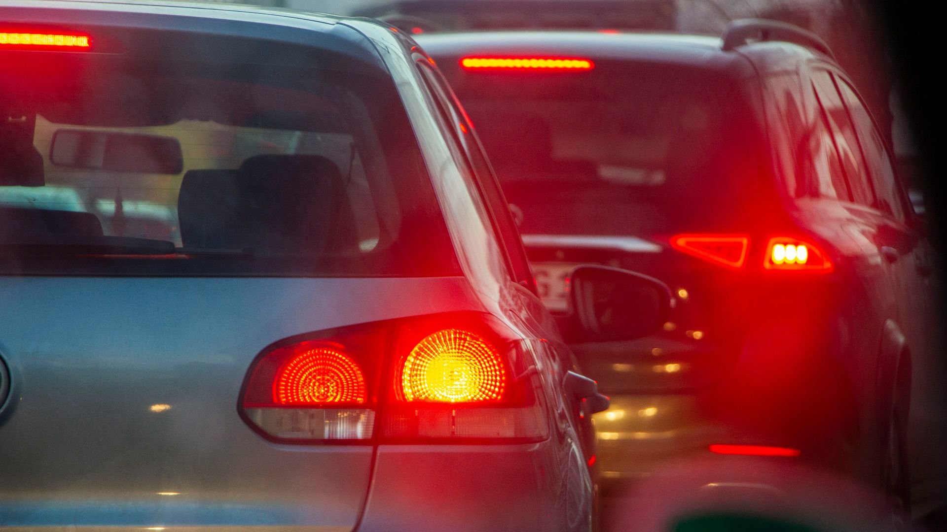 a group of cars driving down a street next to each other