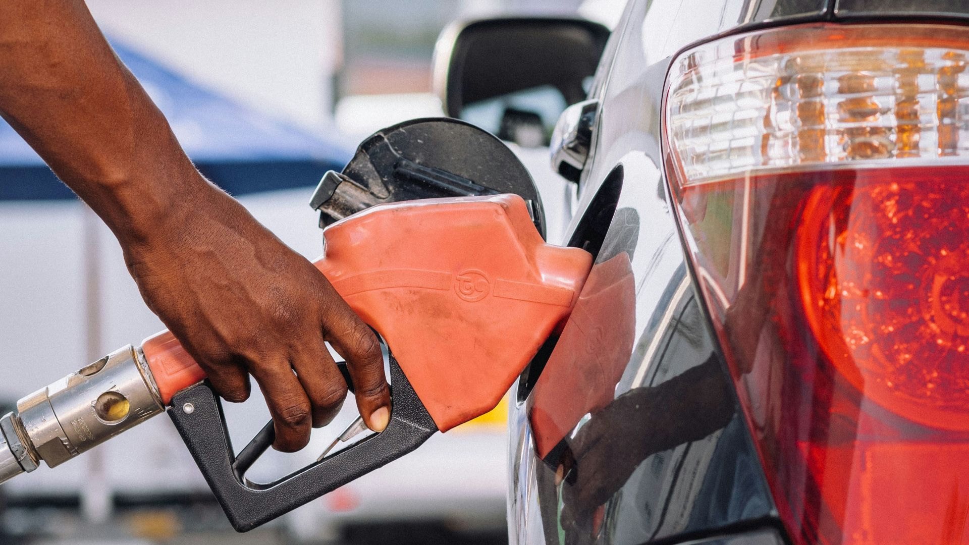a man pumping gas into his car at a gas station