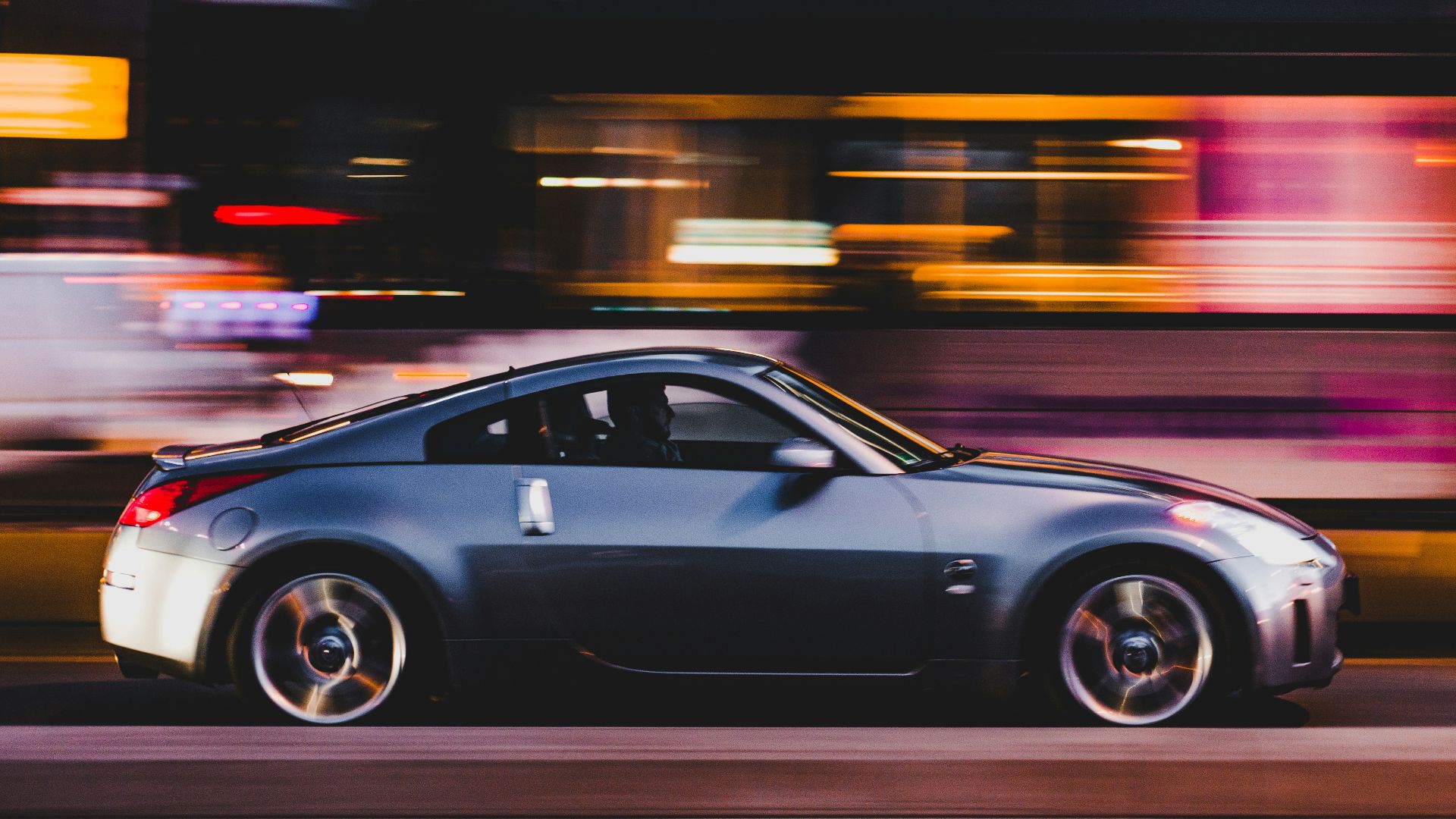 panning photography of gray coupe on road