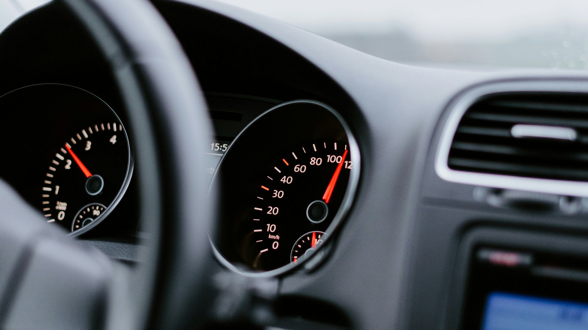black vehicle dashboard with speedometer on 100
