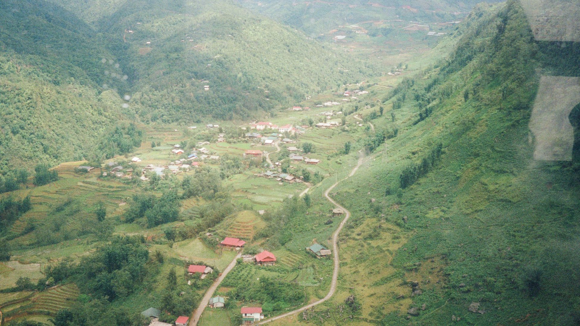 A valley town nestled between lush, green mountains.
