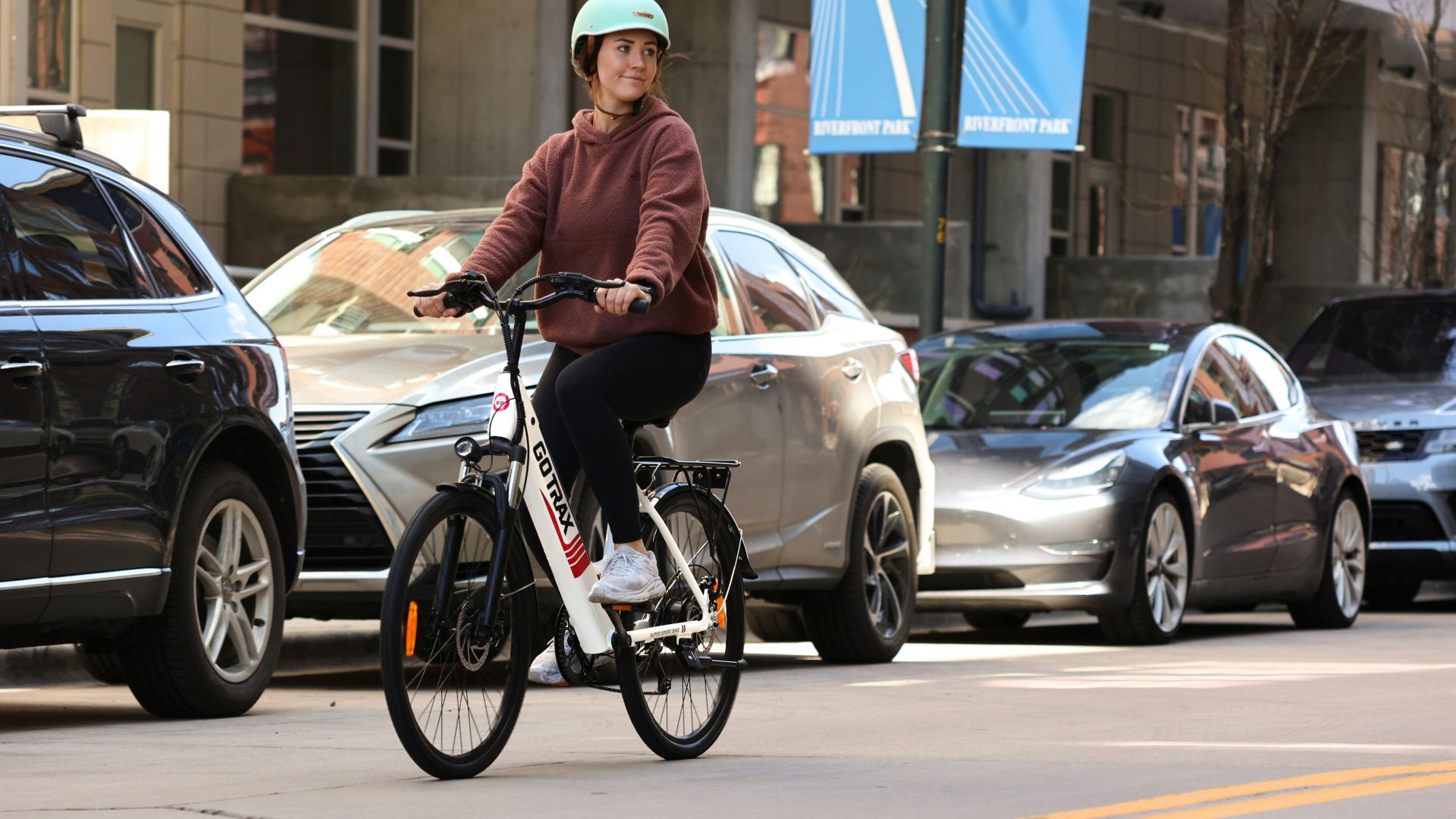 man in brown jacket riding on bicycle during daytime