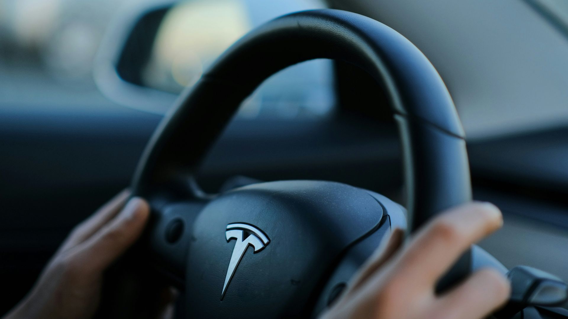 A person holding a steering wheel while driving a car