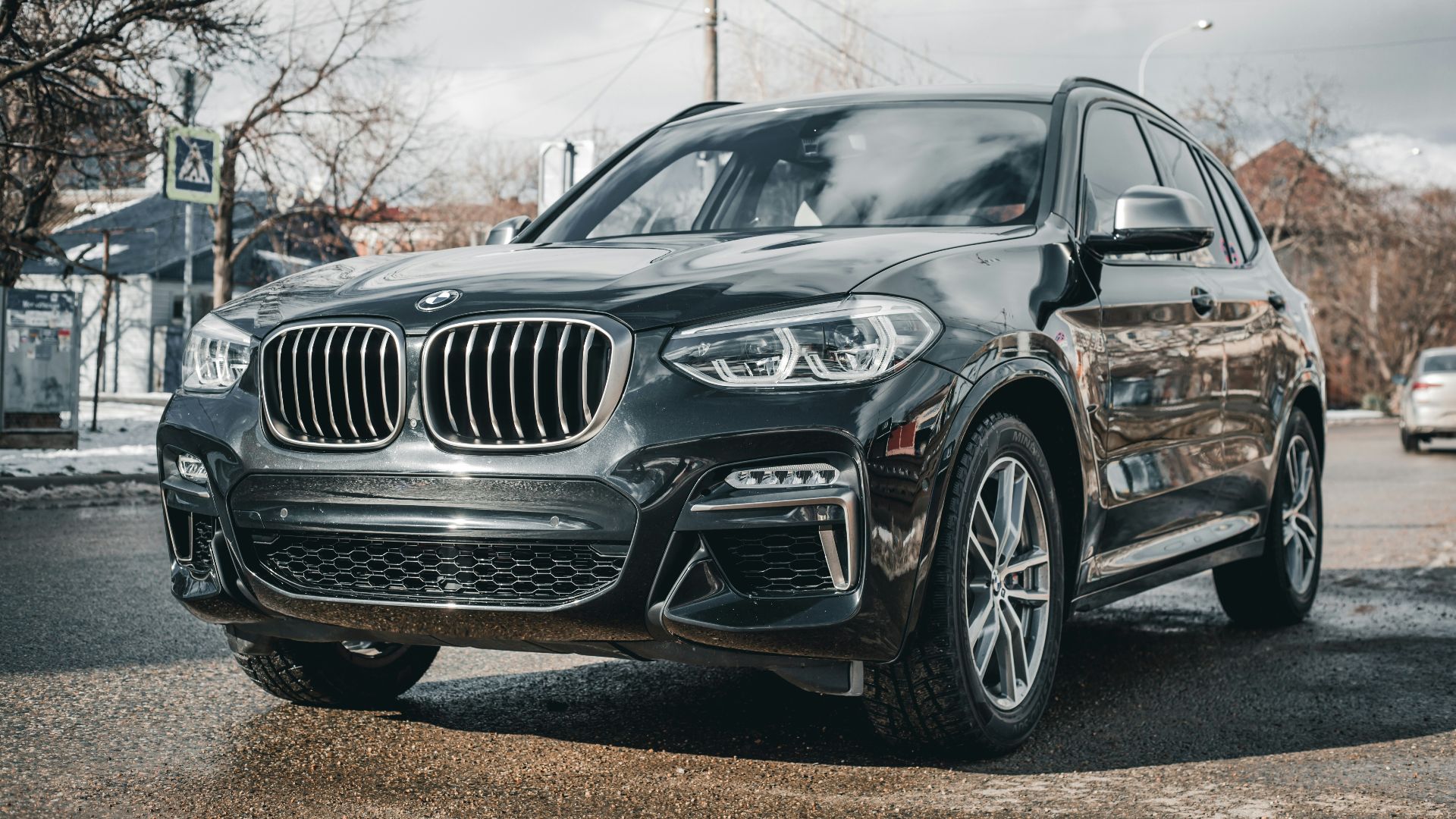 a black bmw suv parked in a parking lot