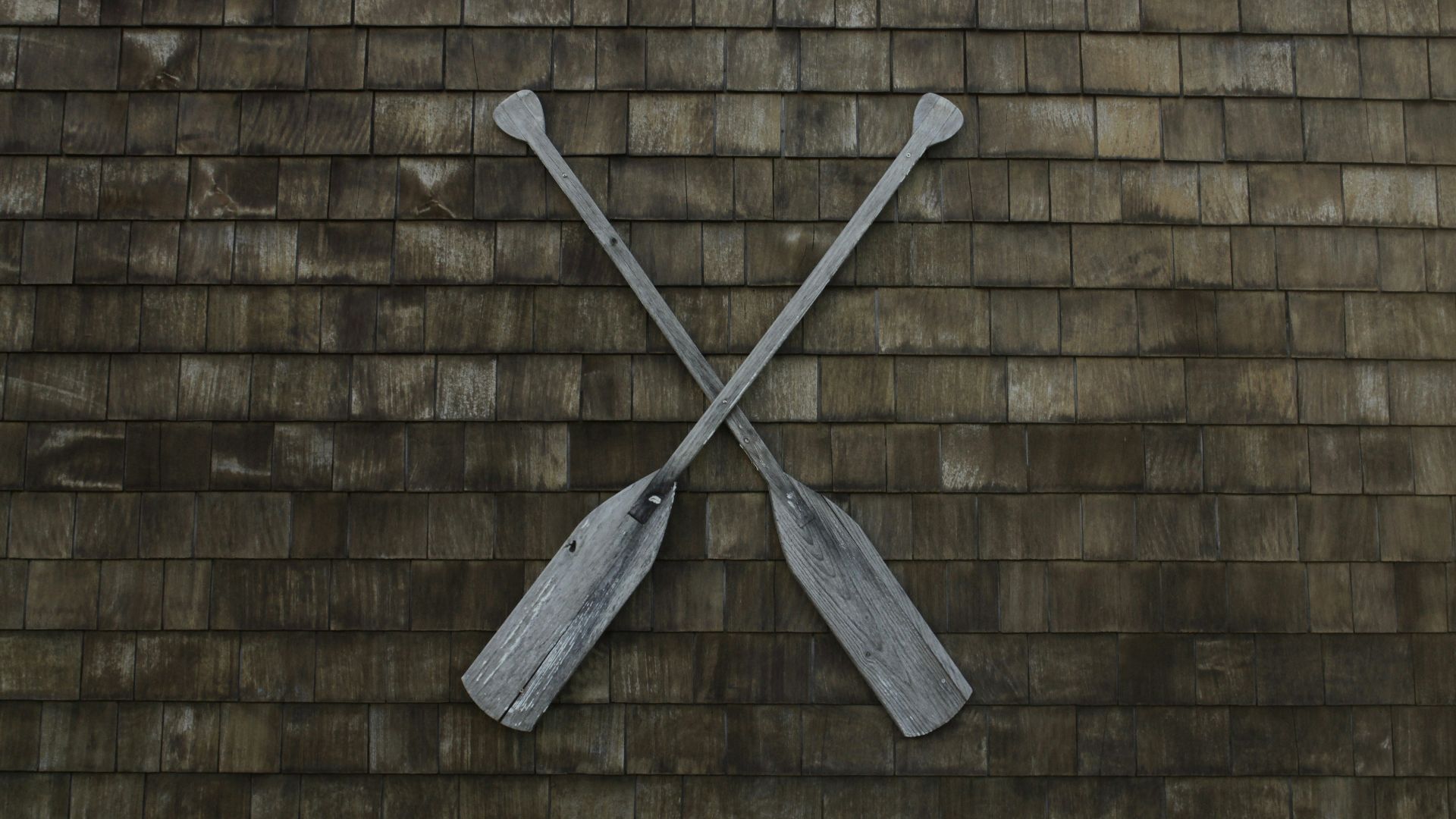 two gray wooden boat paddles hanged on wall