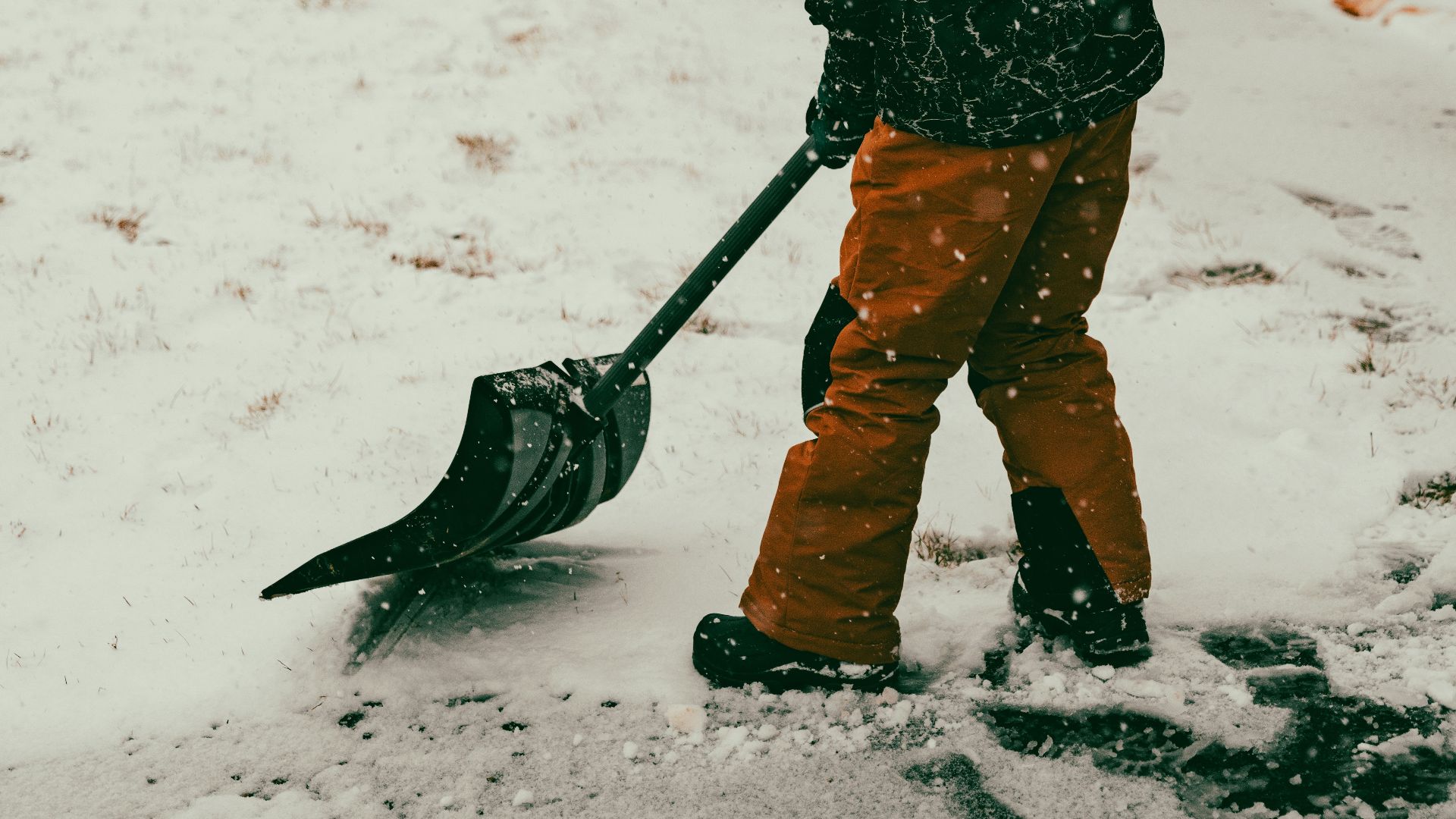 a person with a snow shovel in the snow