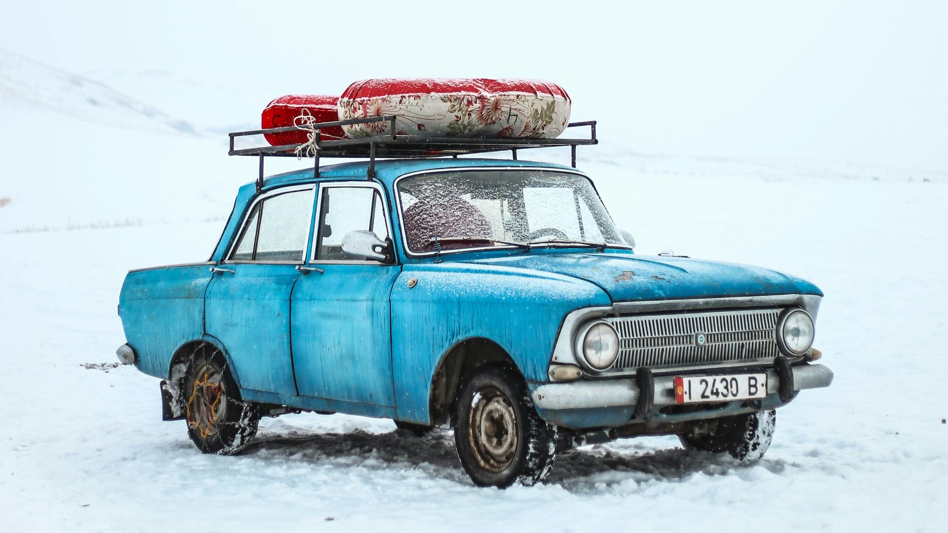 blue sedan on snow ground