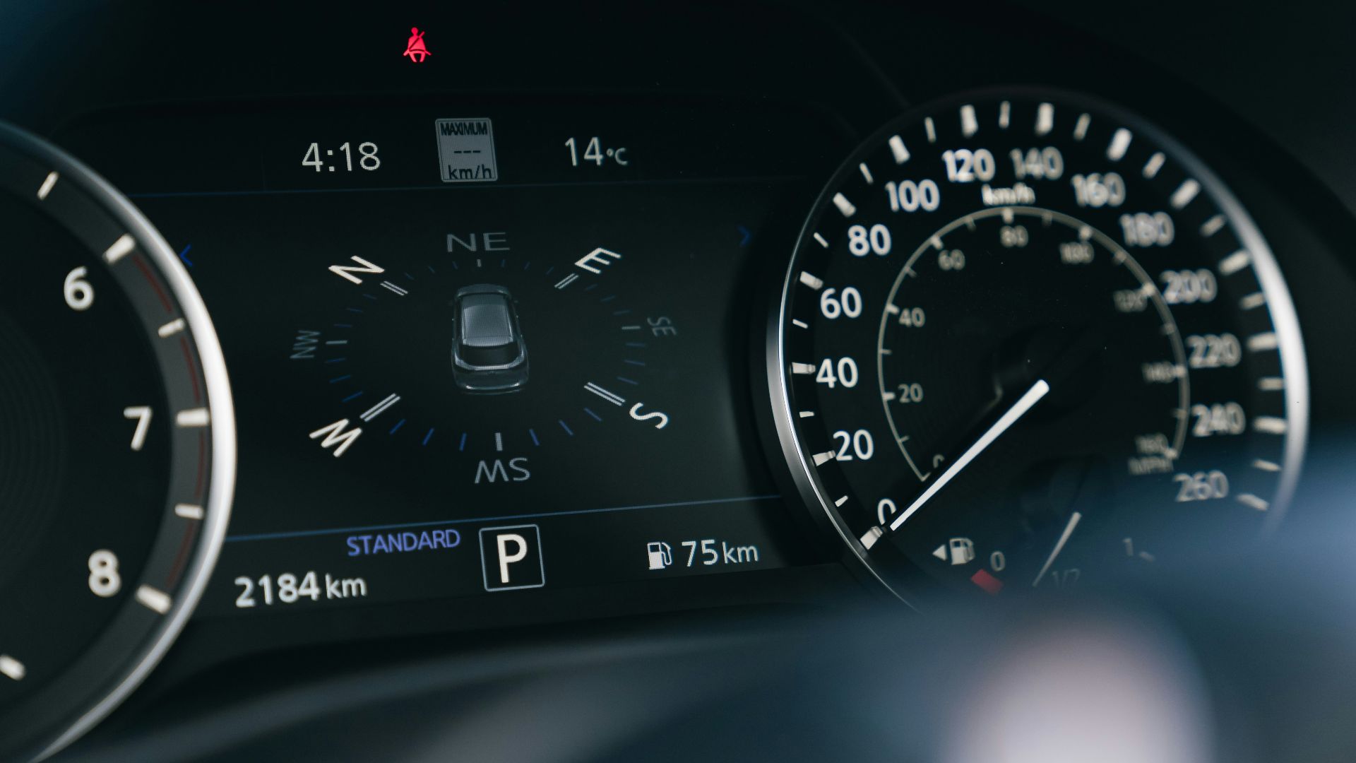 Car dashboard with speedometer and digital display.