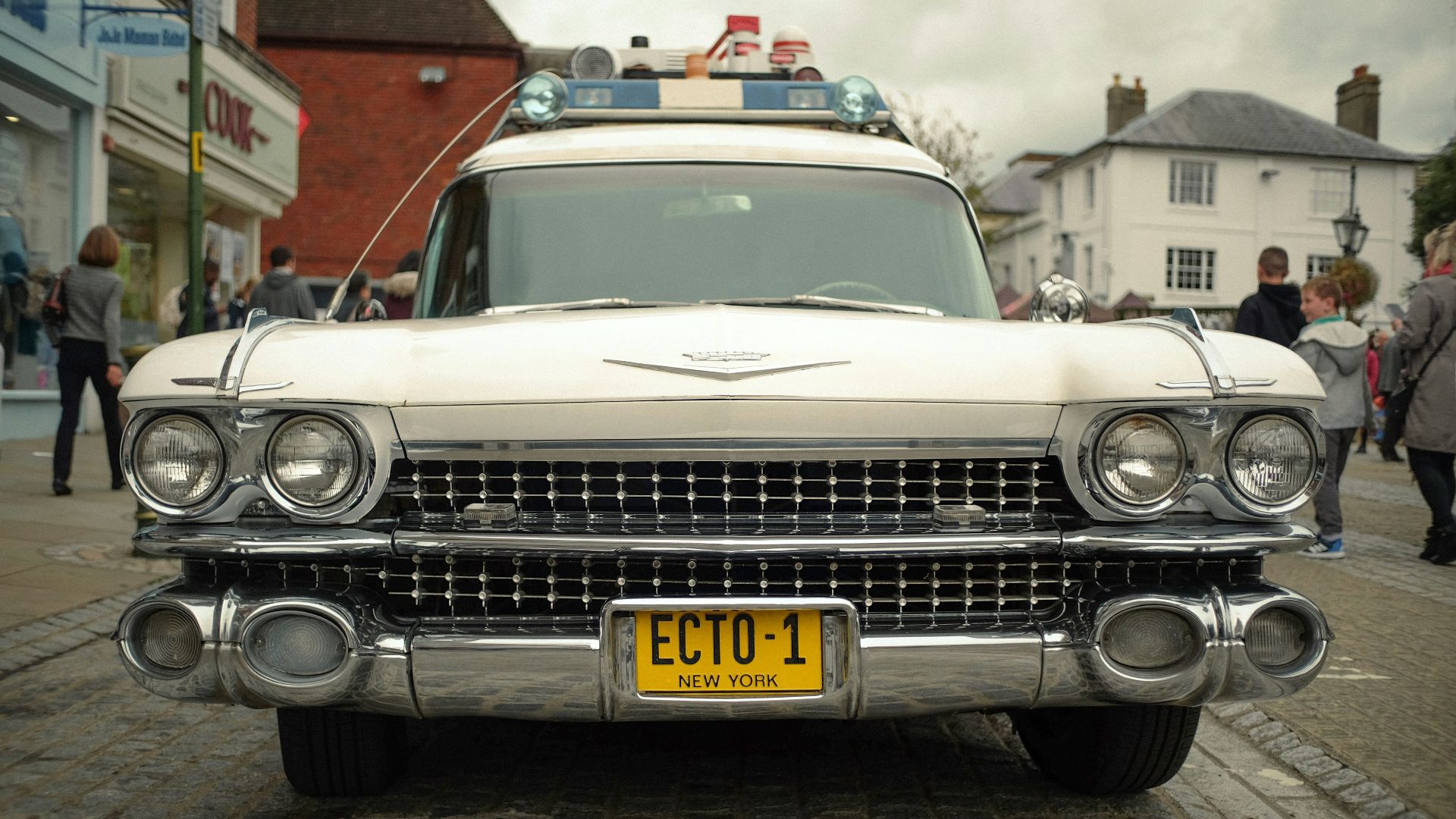 a classic car parked on a cobblestone street