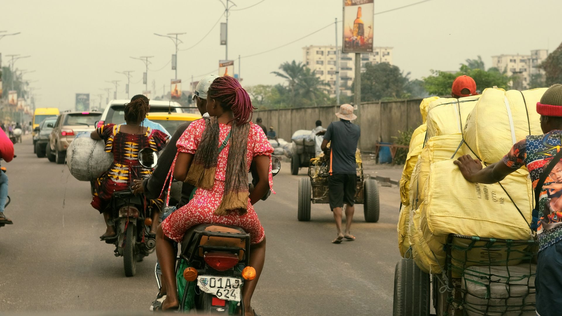 People and traffic fill a bustling city street.