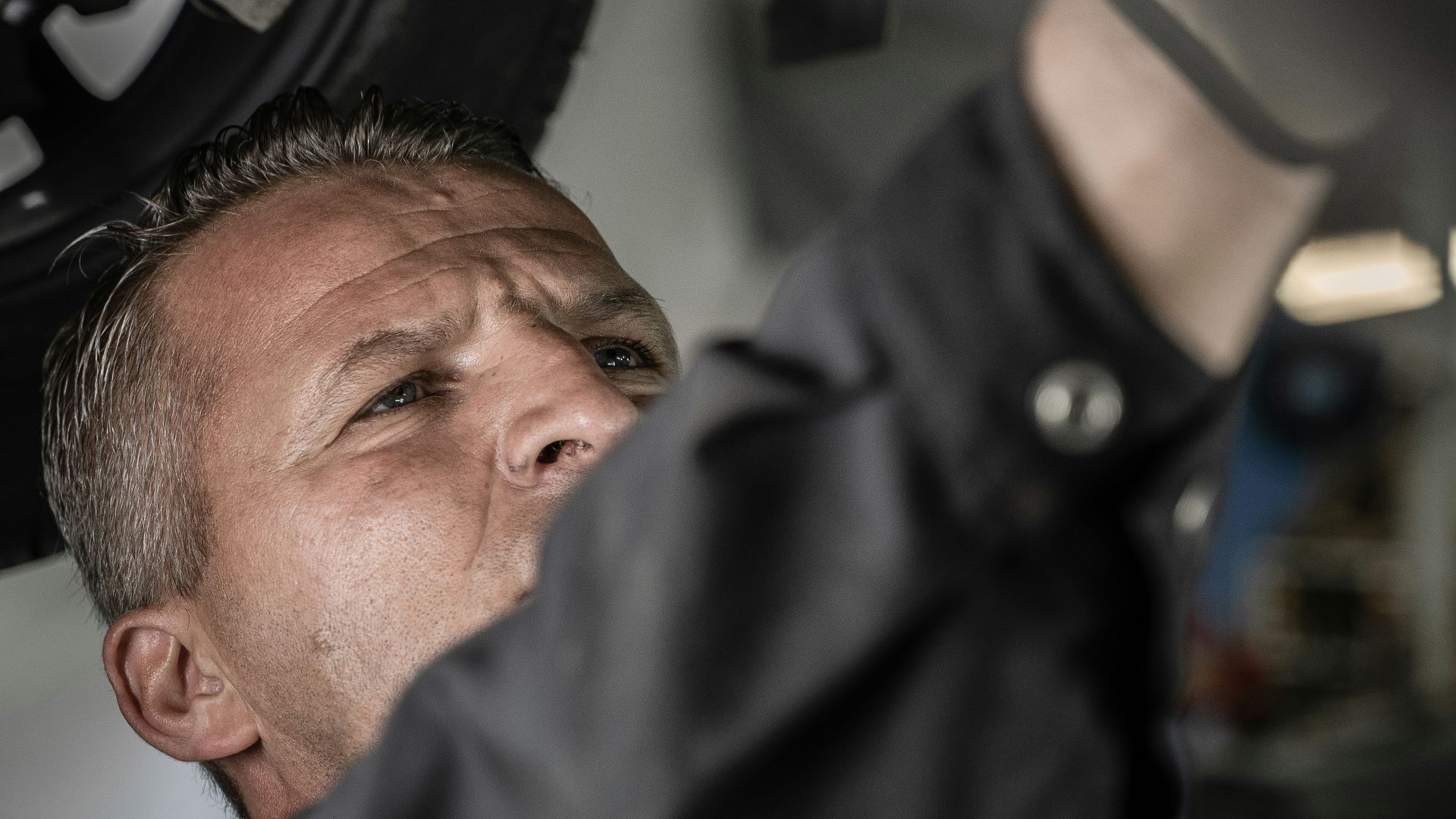 a man working on a car under a vehicle