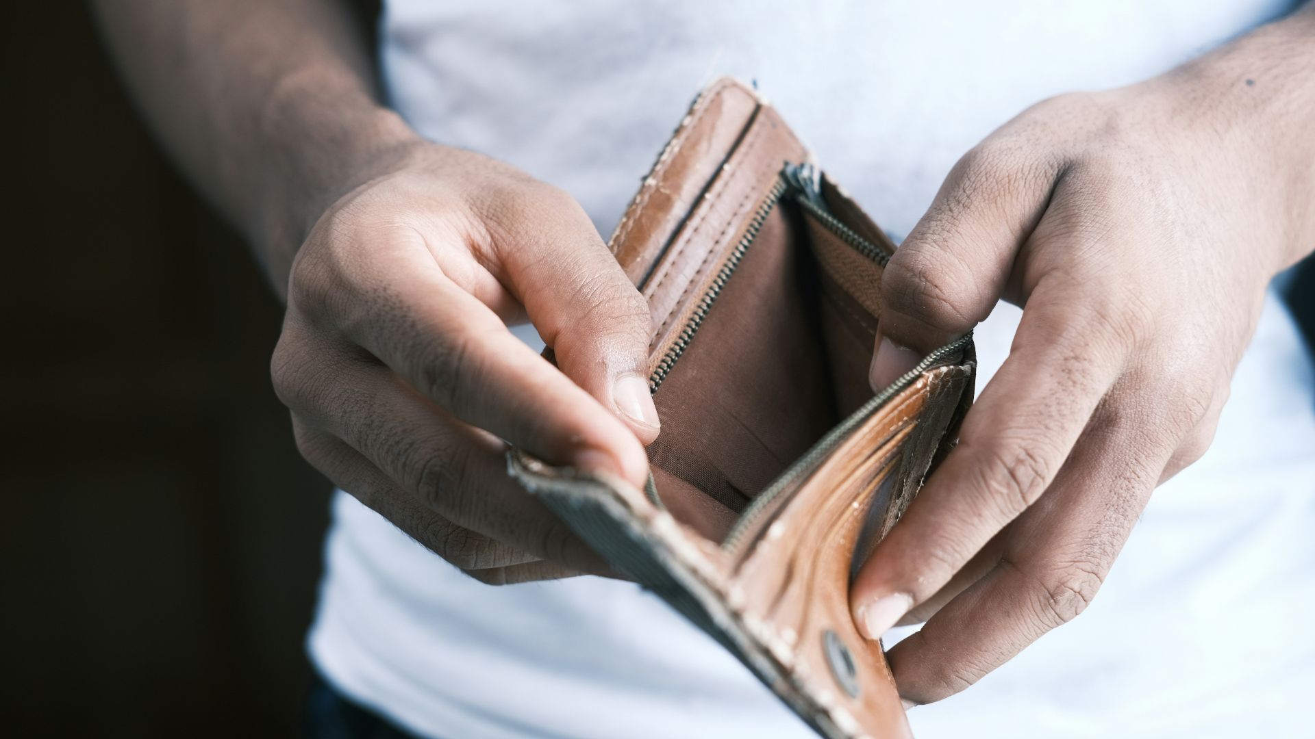 person holding brown leather bifold wallet