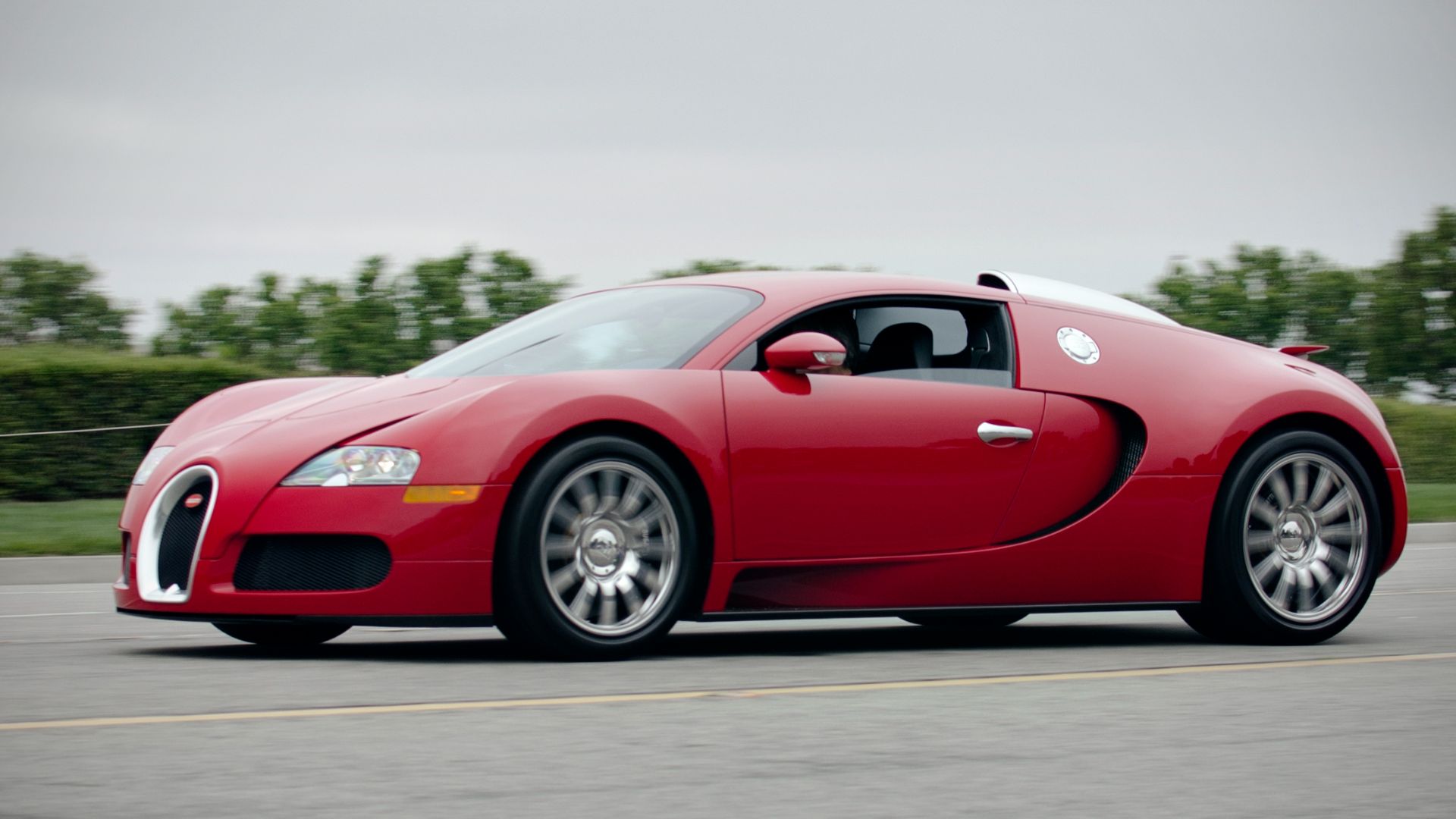 File:Red Bugatti Veyron on the road (7559997596).jpg