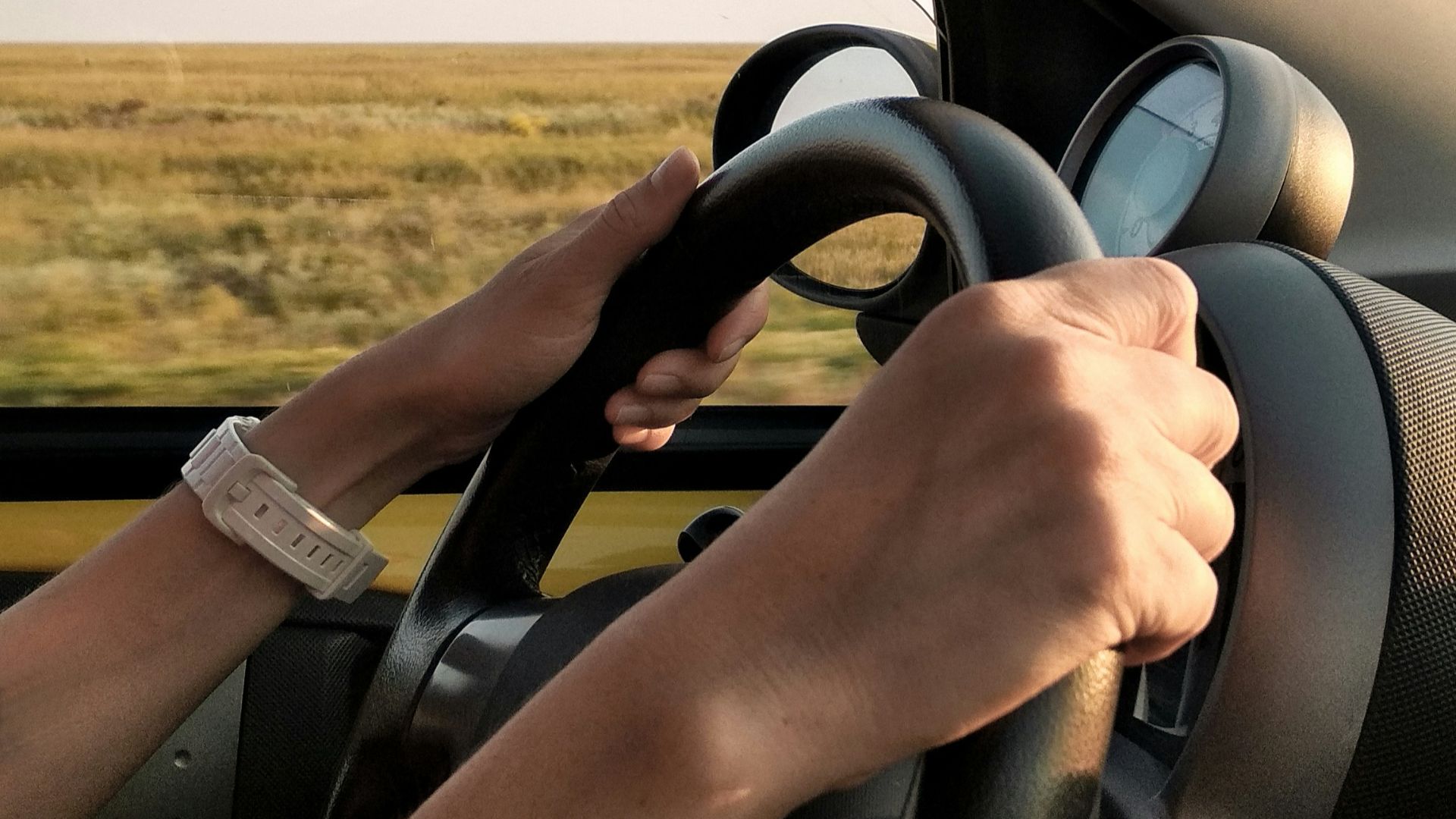 person with white watch driving car