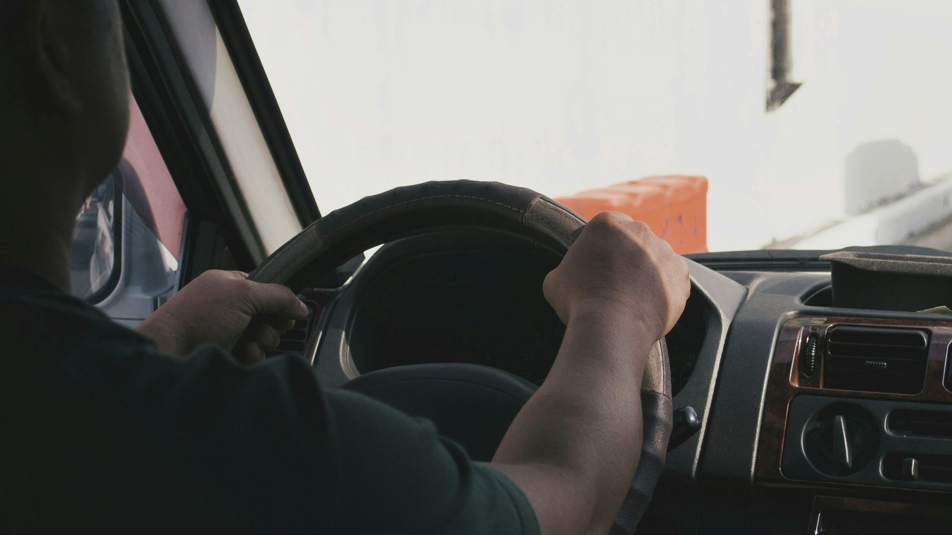 person driving vehicle on road near vehicle at daytime