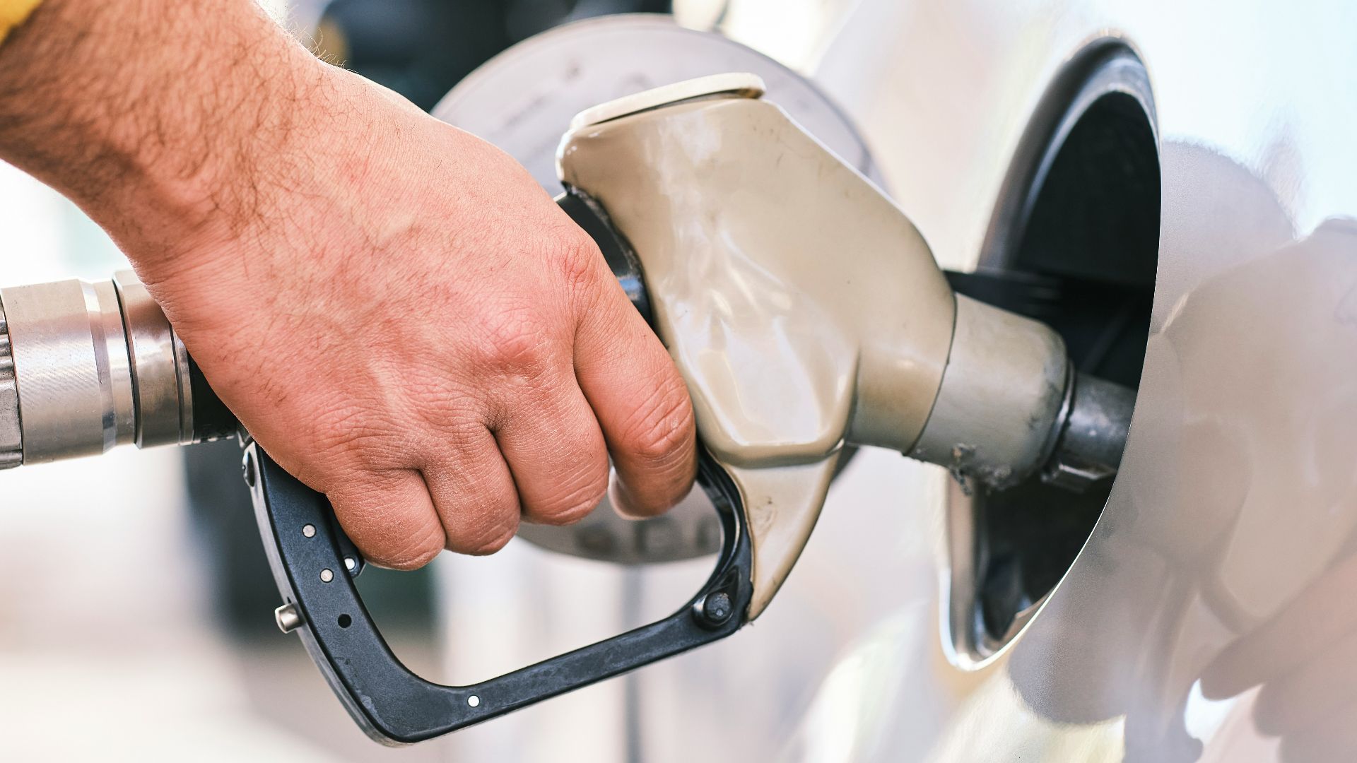 a man pumping gas into his car at a gas station