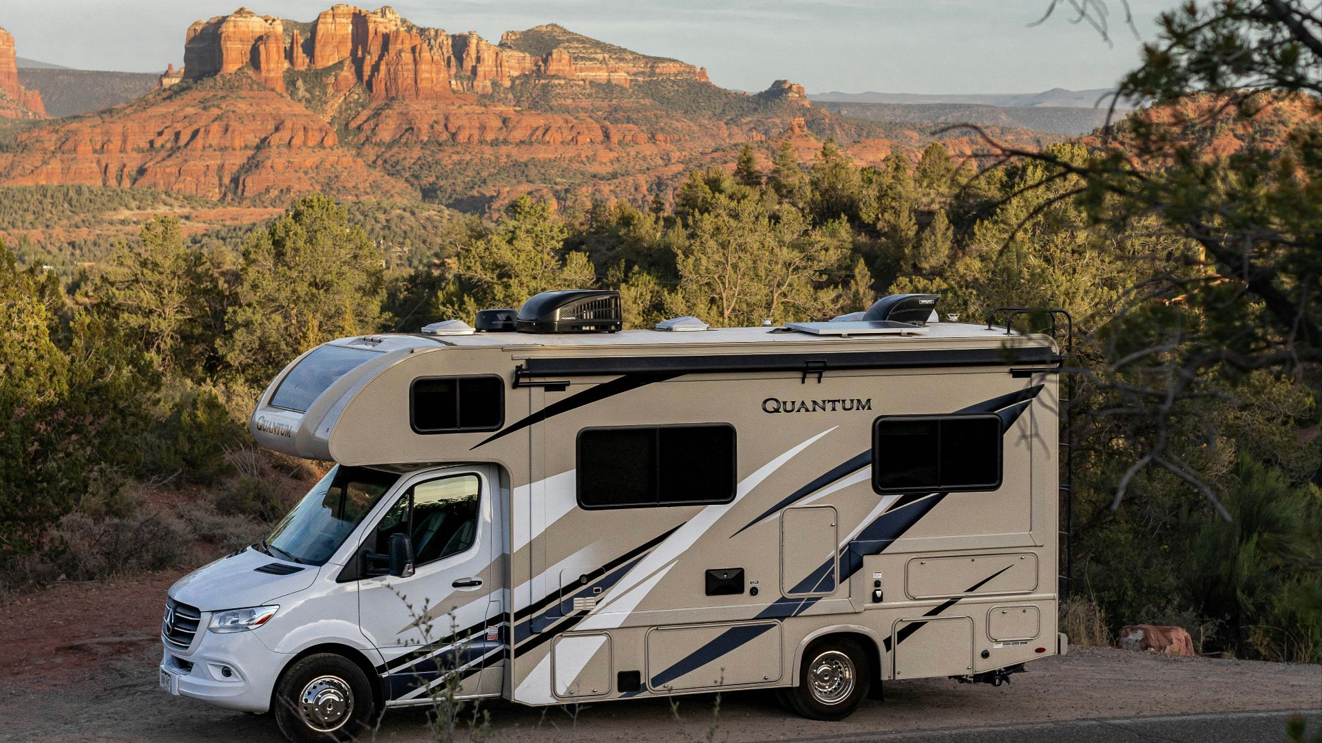 a white van parked on a road with trees and mountains in the background