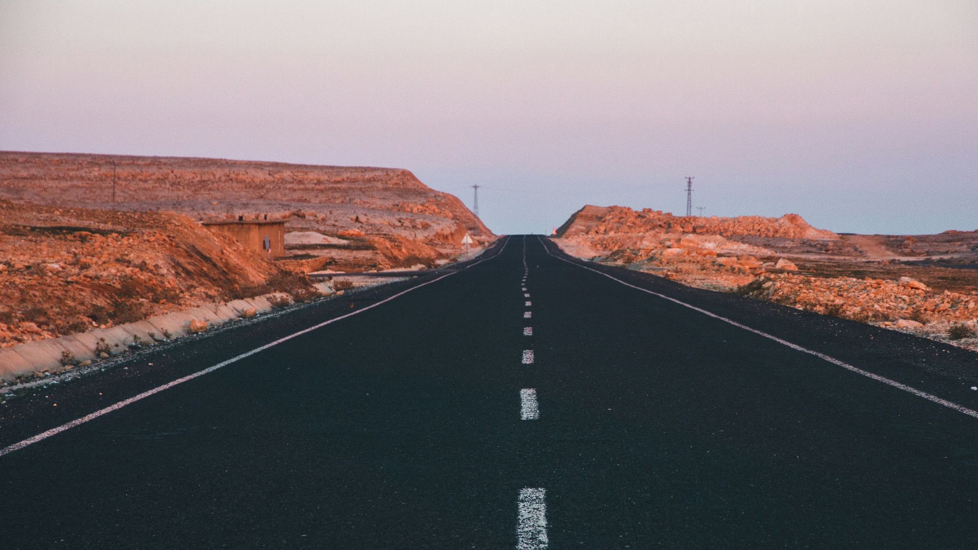 an empty road in the middle of a desert
