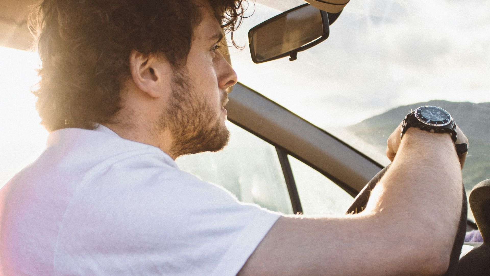 man holding steering wheel