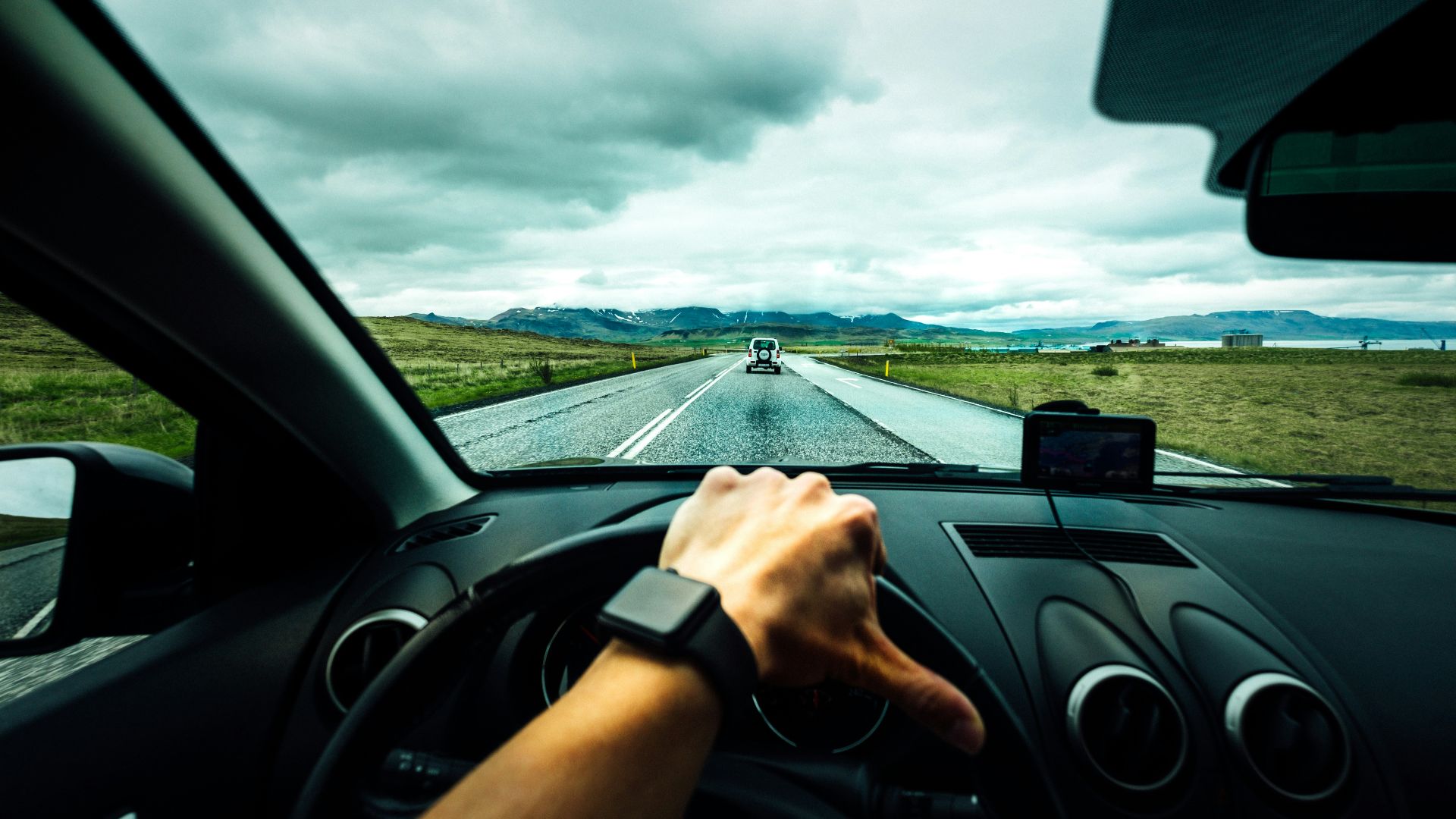 person driving car near vehicle under nimbus cloudes