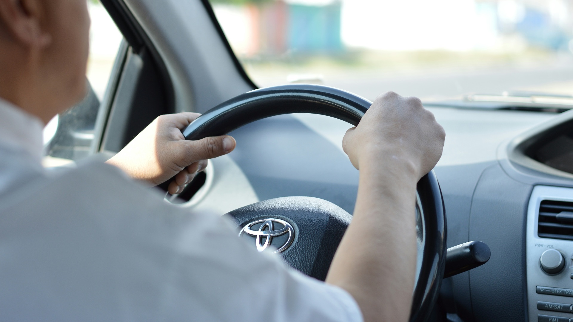 person in white long sleeve shirt driving car