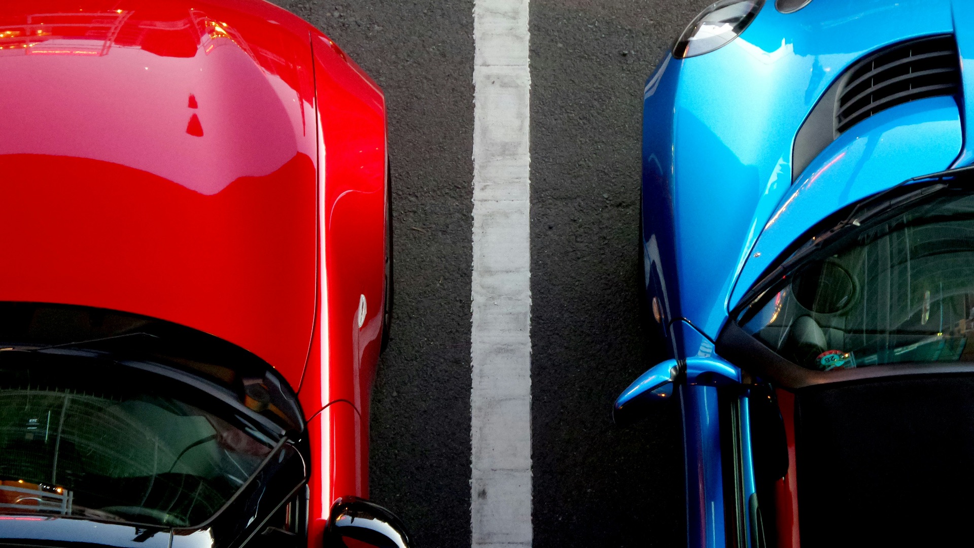 top view photo of red and blue convertibles on asphalt road