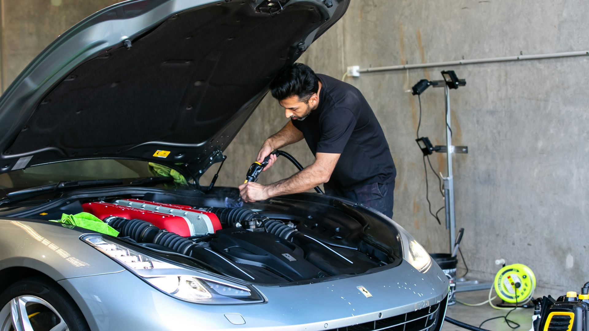 A mechanic is working on a ferrari car.