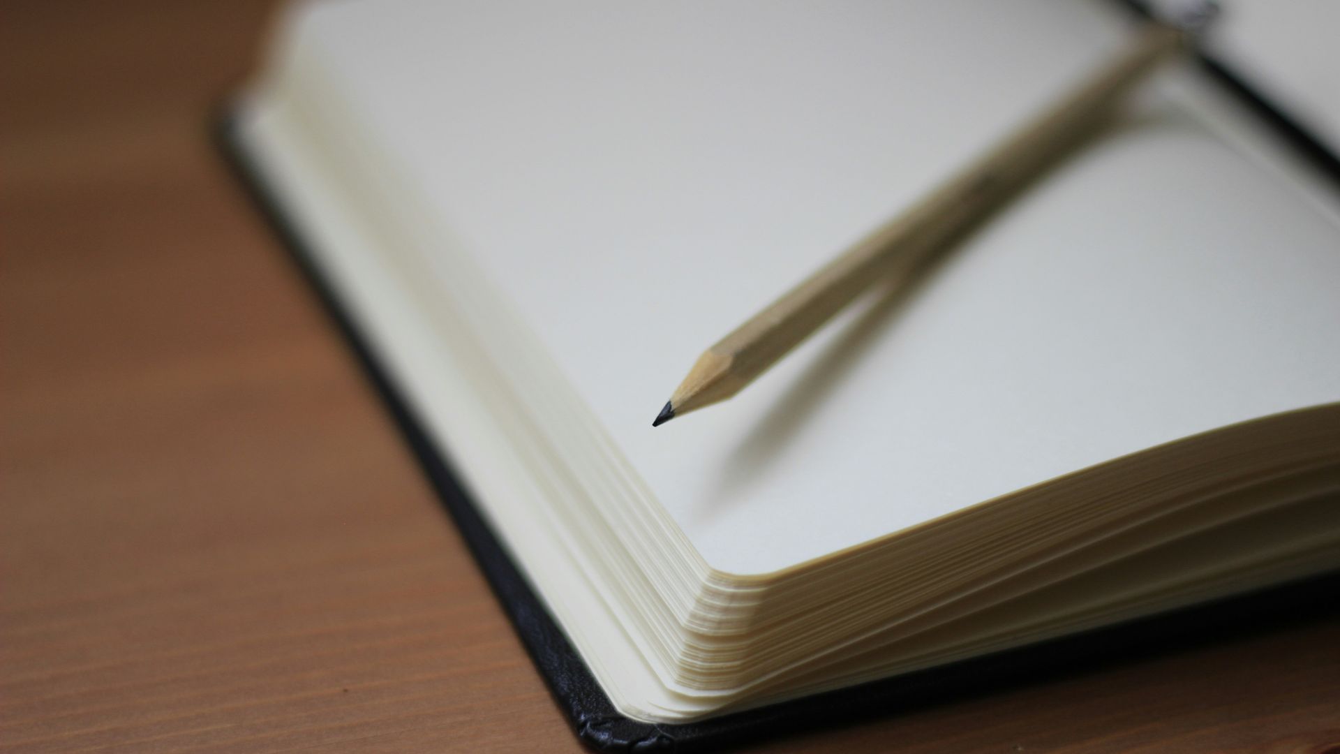 shallow focus photography of pencil on book