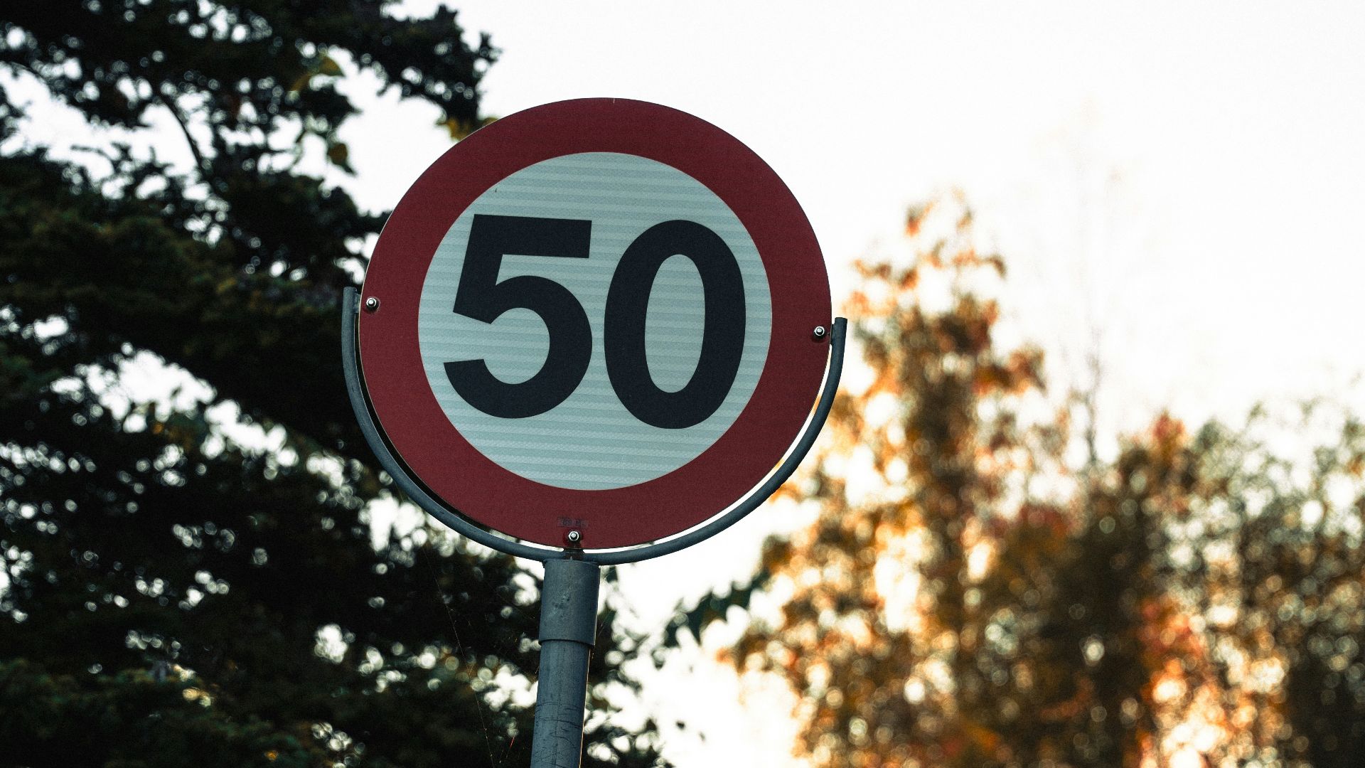 A red and white sign sitting on the side of a road