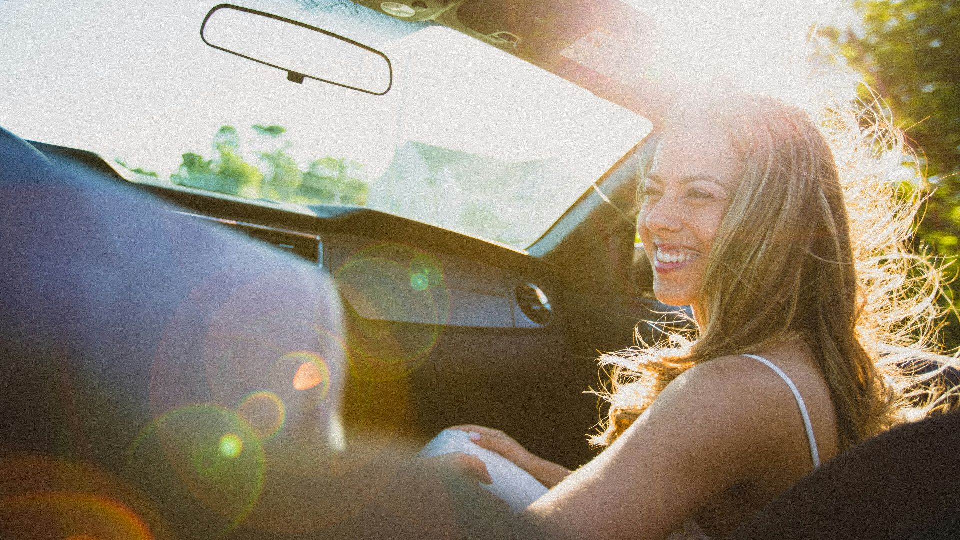 smiling woman sitting inside the vehicle at daytime