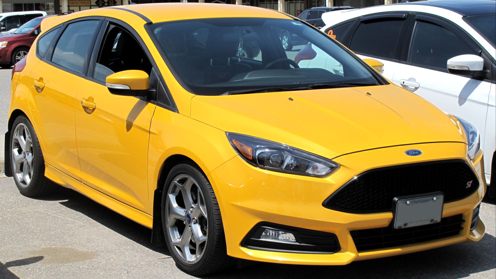 File:2015 Ford Focus ST in Tangerine Scream Metallic Tri-coat, Front Right, 05-29-2022.jpg