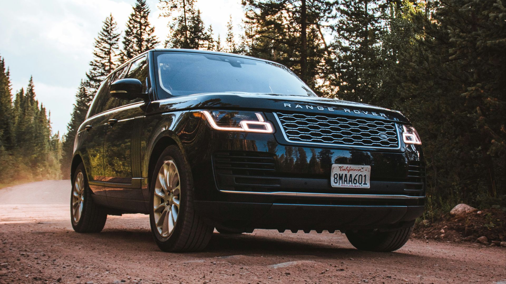a black suv parked on a dirt road