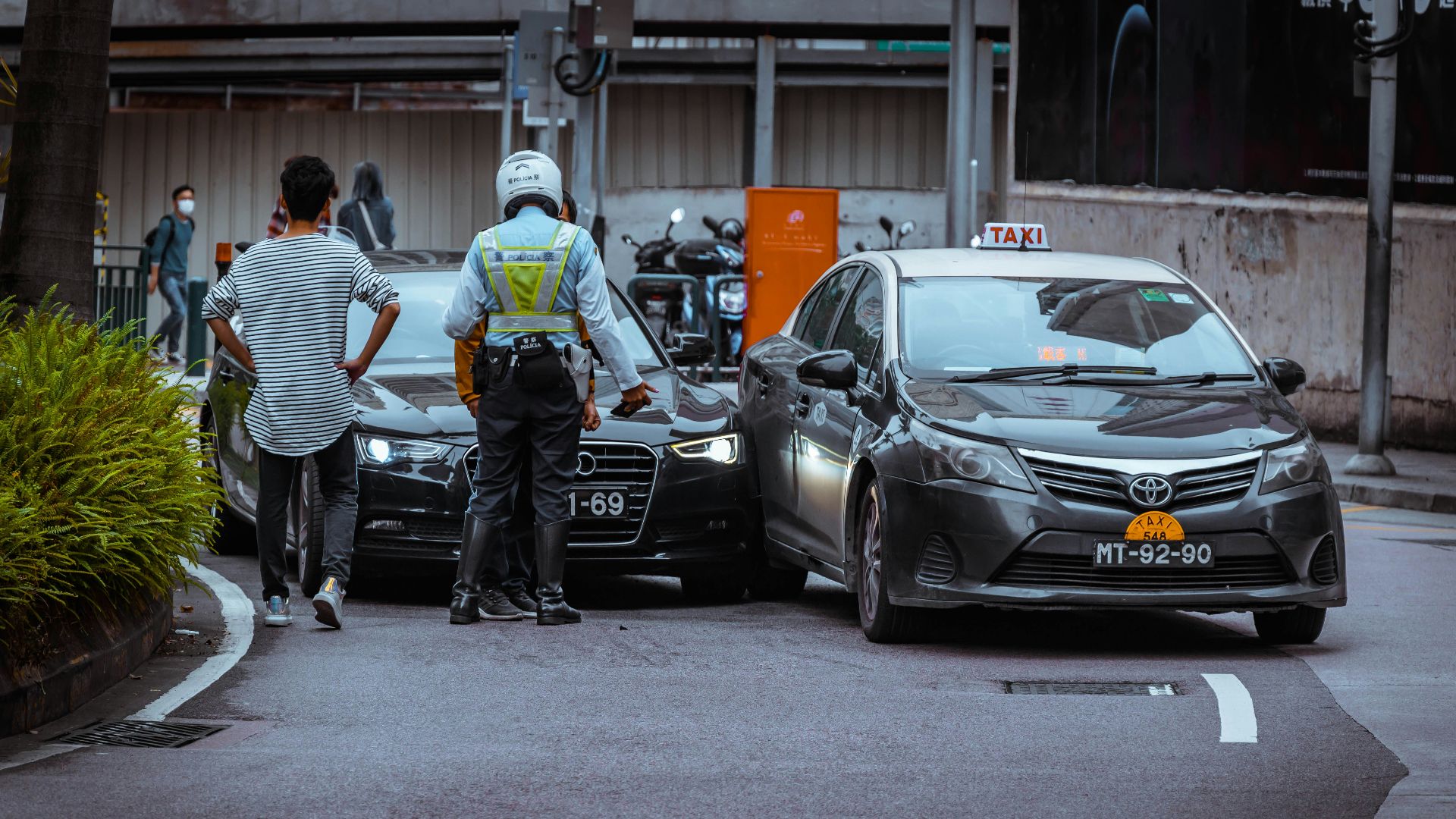 man in white and black stripe shirt and black pants standing beside black car during daytime