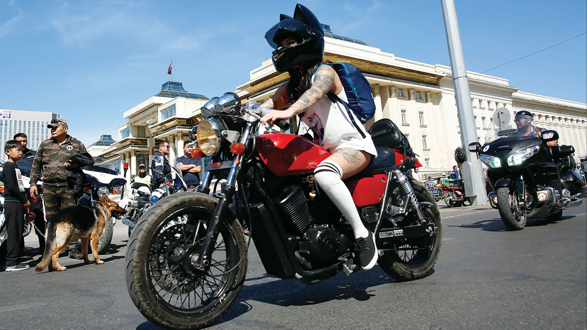 person wearing white tank top riding red motorcycle