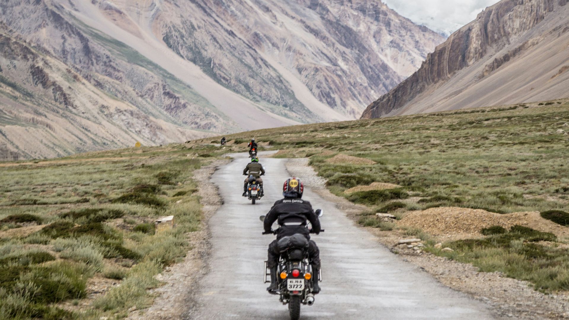 two motorcycles driving on grey road