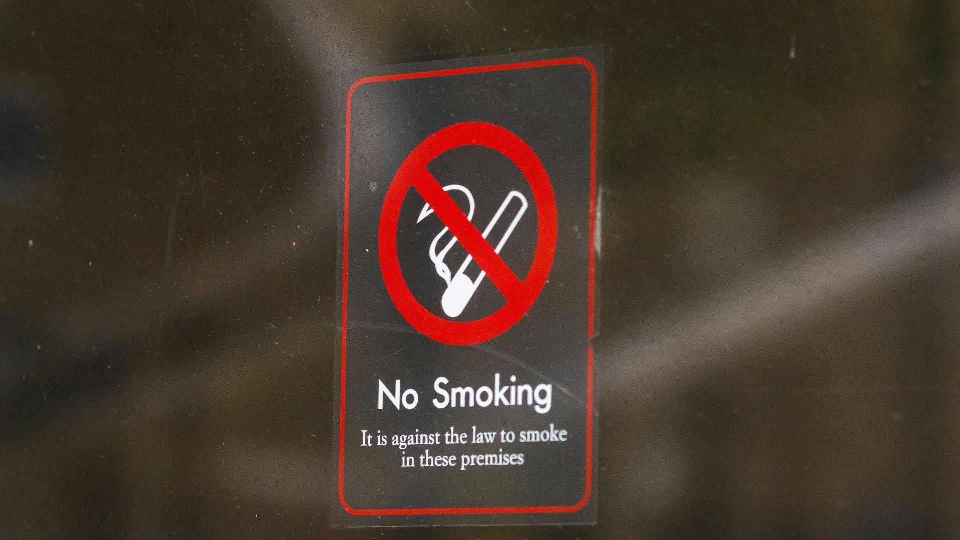 a no smoking sign on a glass door
