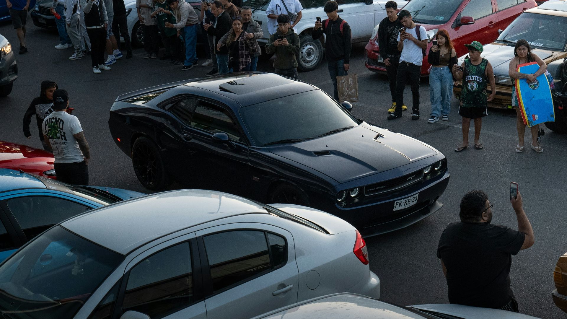 a crowd of people standing around a parking lot