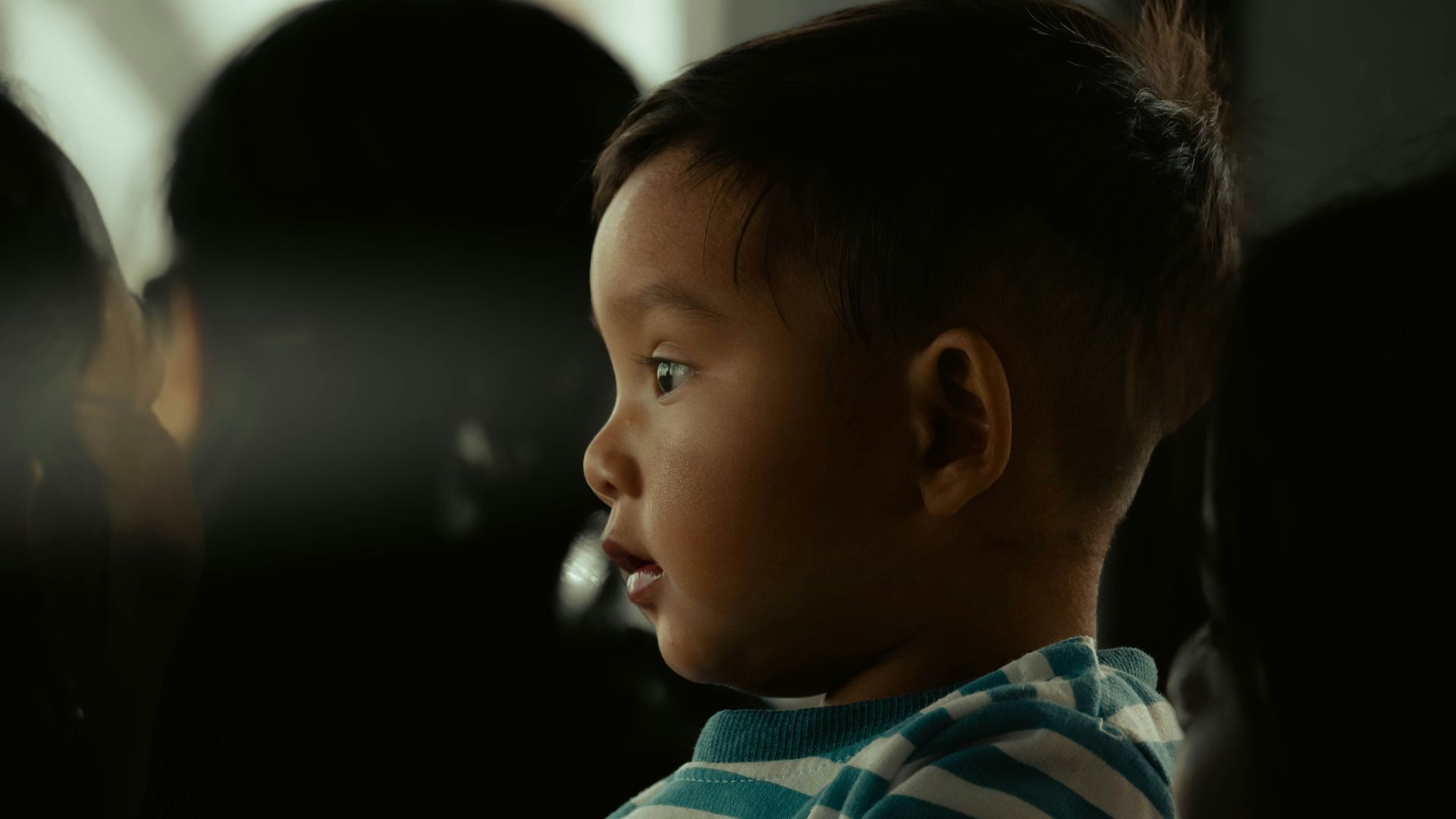 a small child is looking out the window