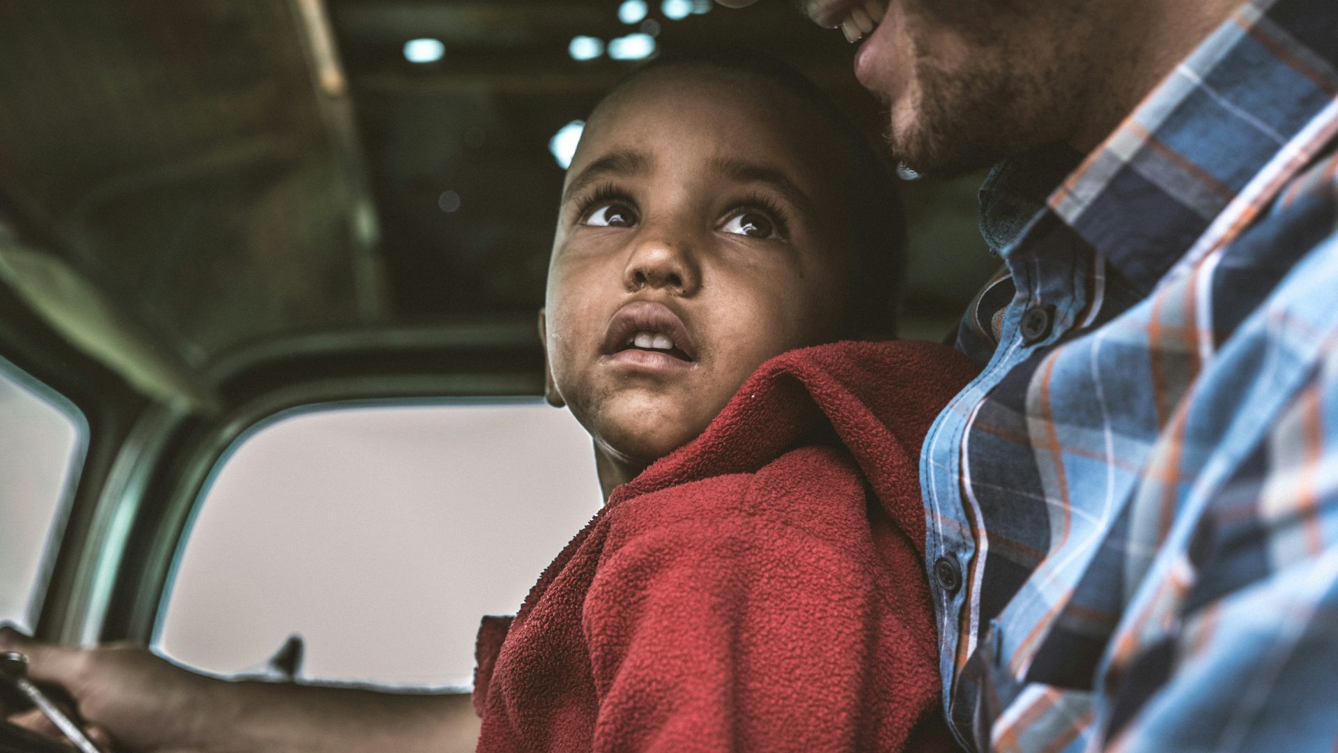 man in red hoodie sitting inside car
